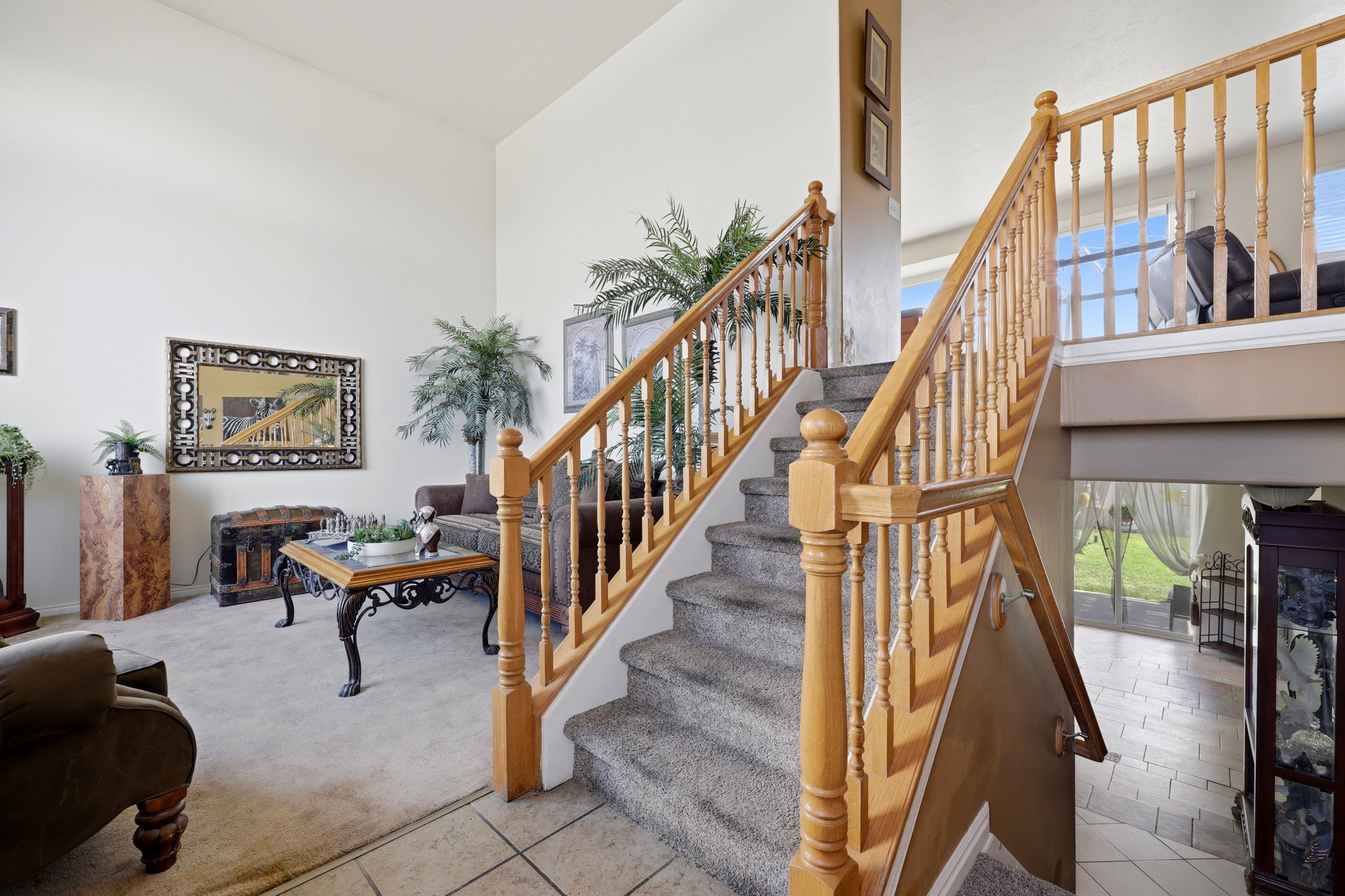 Split-level staircase featuring natural wood banisters and balusters