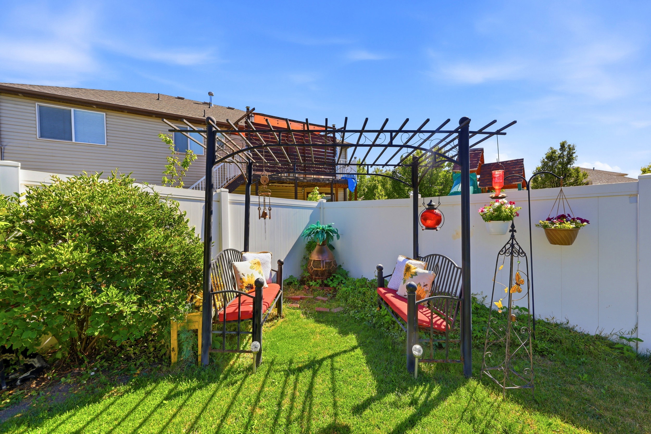 Lush green lawn with a white privacy fence