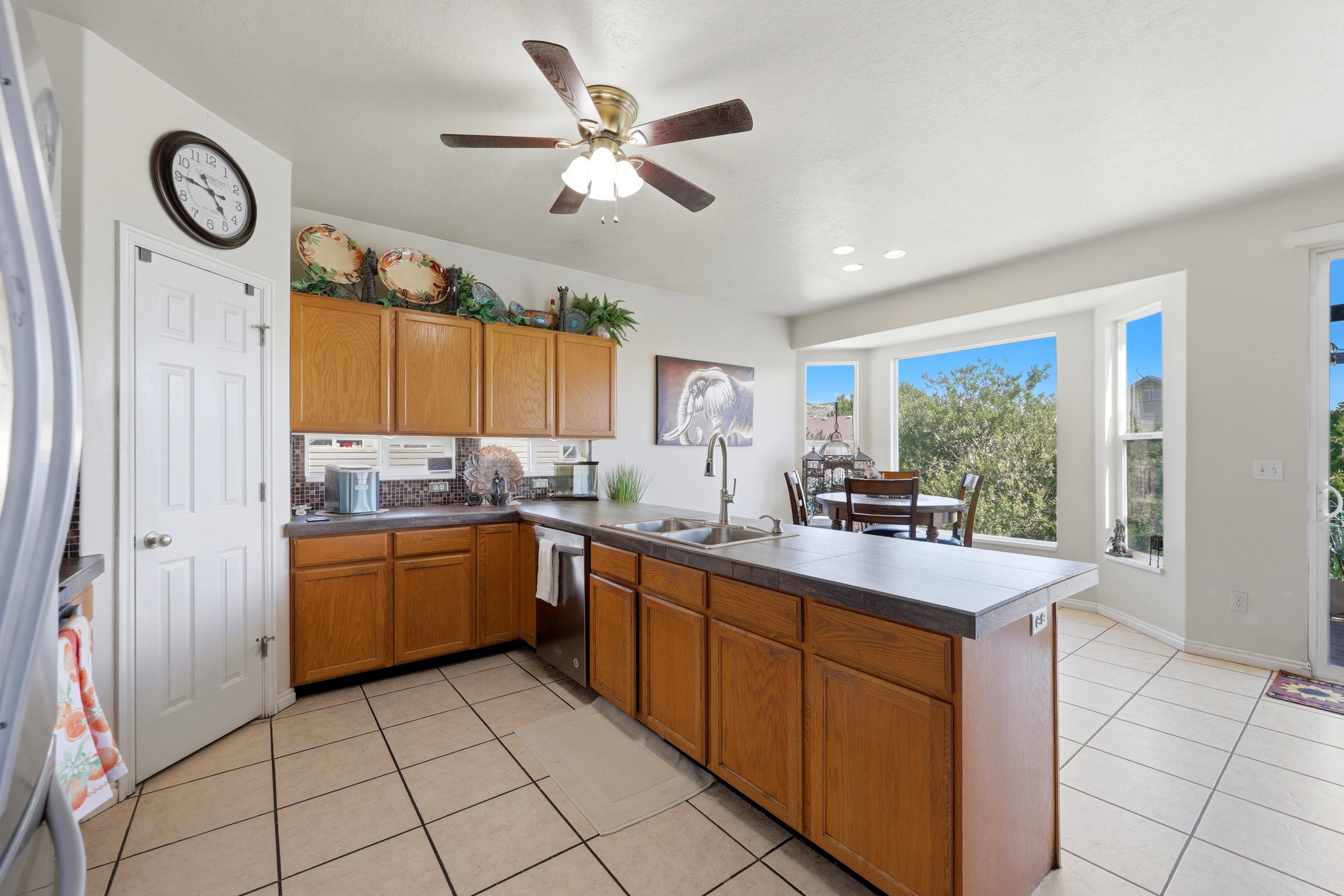 Kitchen featuring wood-finish cabinetry, tile flooring, and a ceiling fan