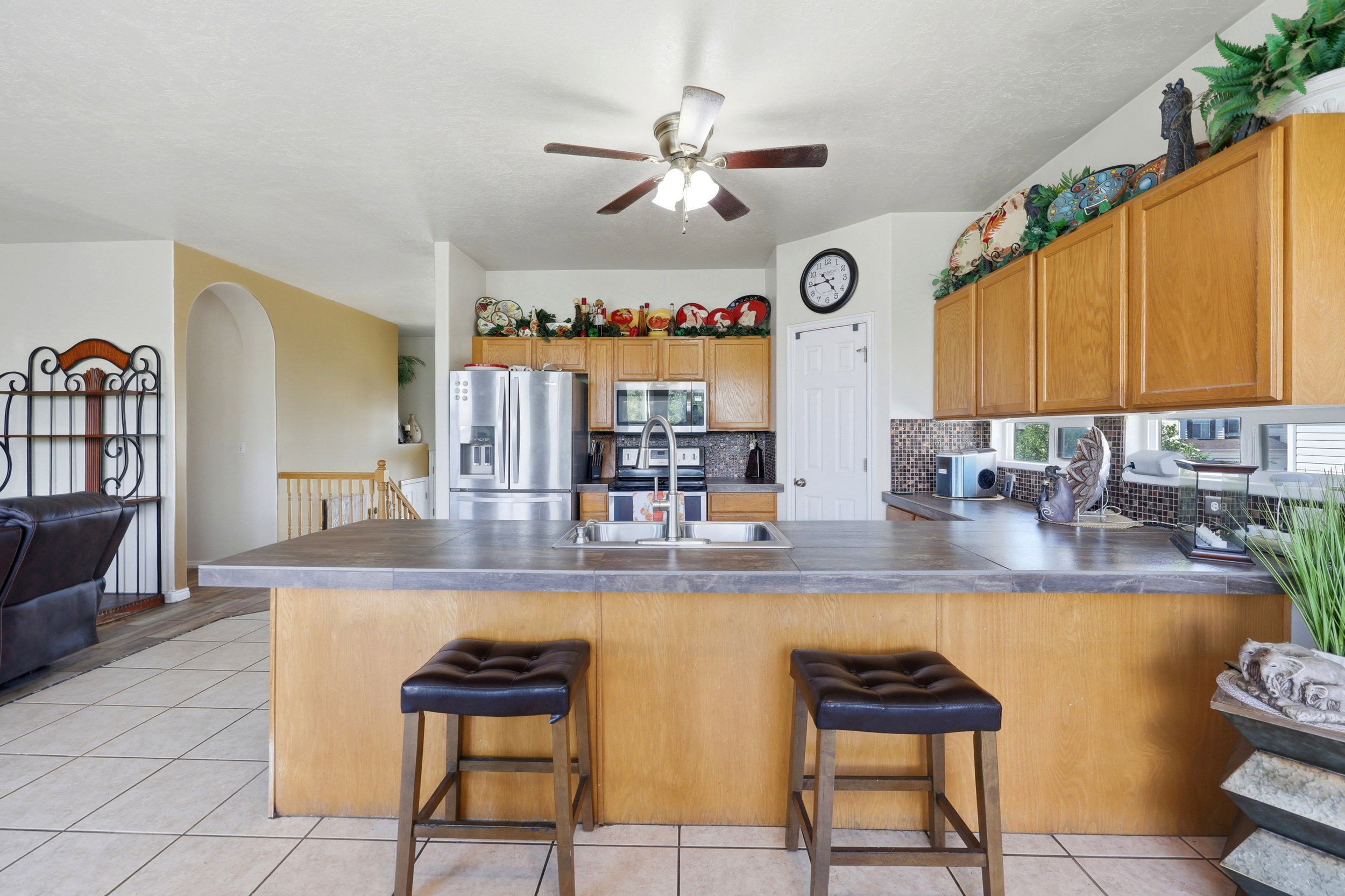Kitchen featuring wood-finish cabinetry, stainless steel appliances, and a central island with integrated sink