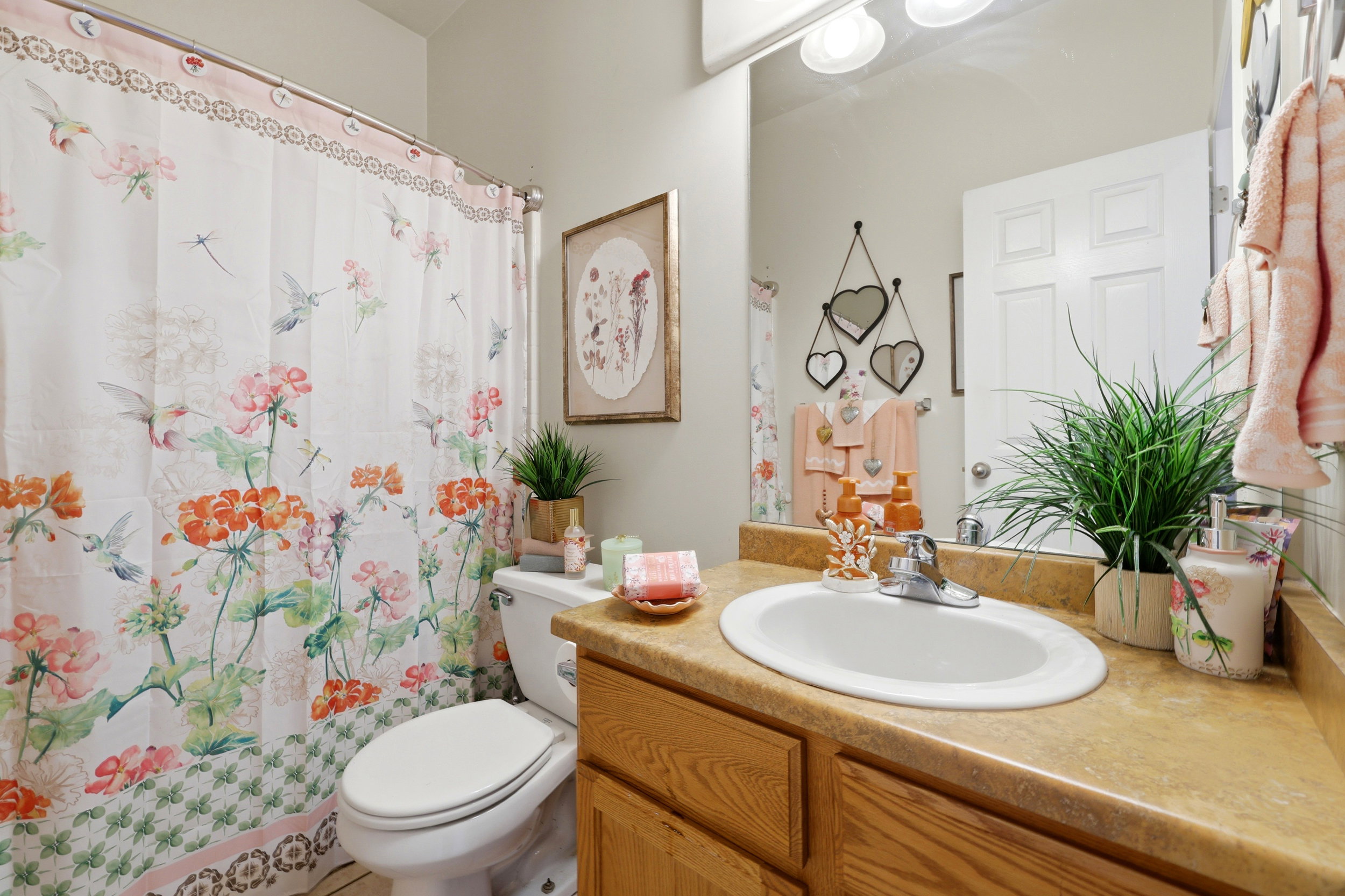 Bathroom featuring a light wood-finish vanity with a built-in oval sink and a light-colored countertop