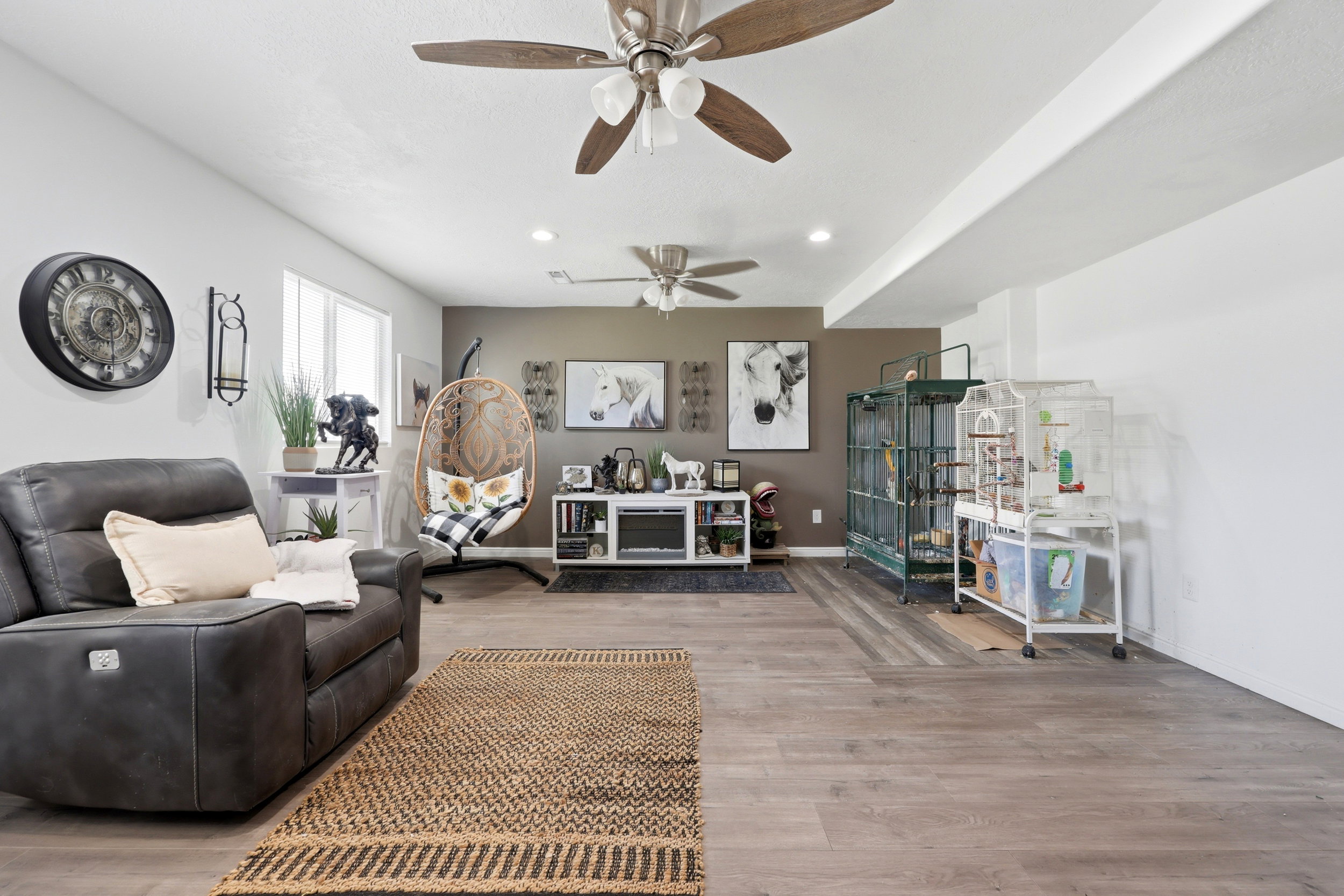 Spacious living area featuring wood-finish flooring, recessed lighting, and dual ceiling fans
