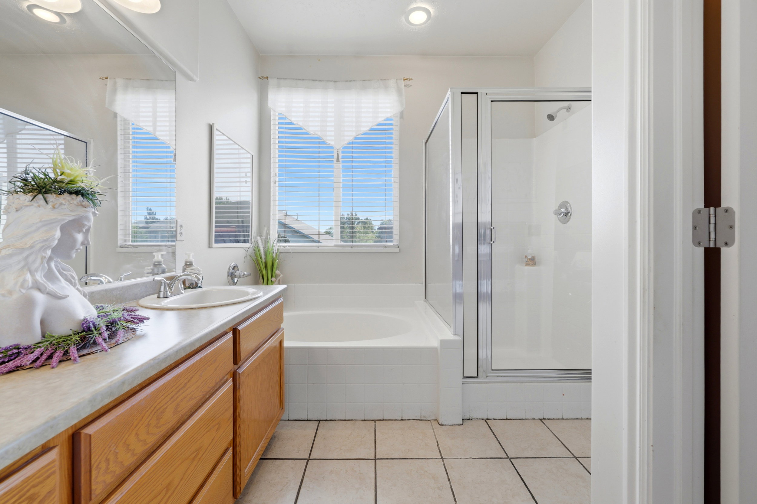 Bathroom with dual windows, an integrated bathtub, and a glass-enclosed shower
