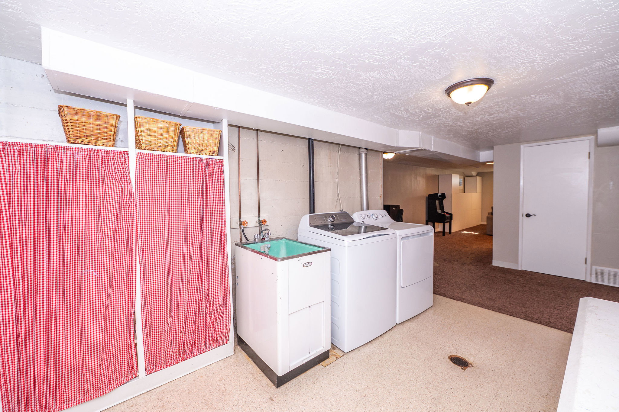 Dedicated laundry area featuring a utility sink and permanent overhead lighting