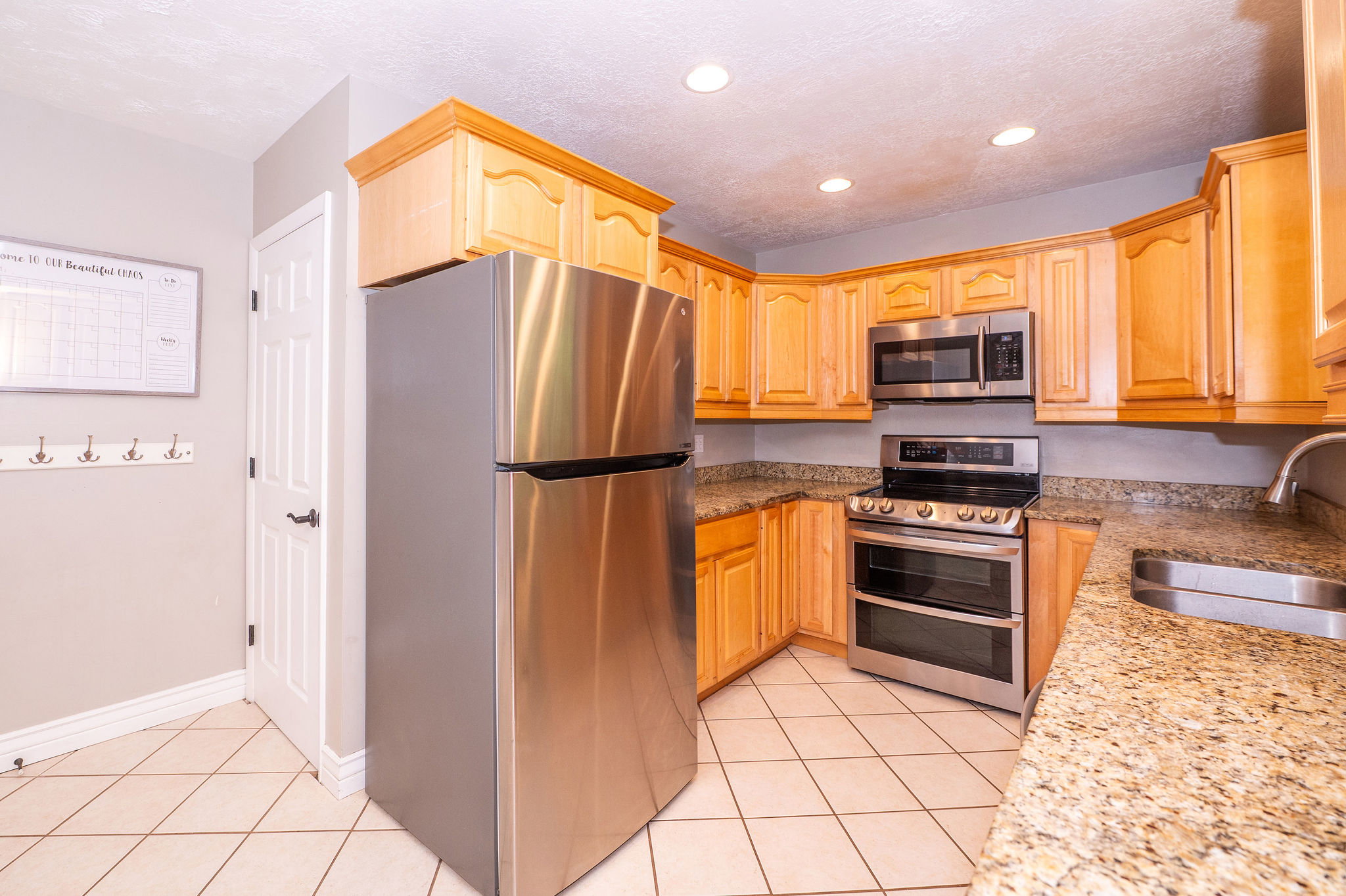 Kitchen featuring ample cabinetry, granite-finish countertops, and stainless steel appliances including a double oven range and microwave