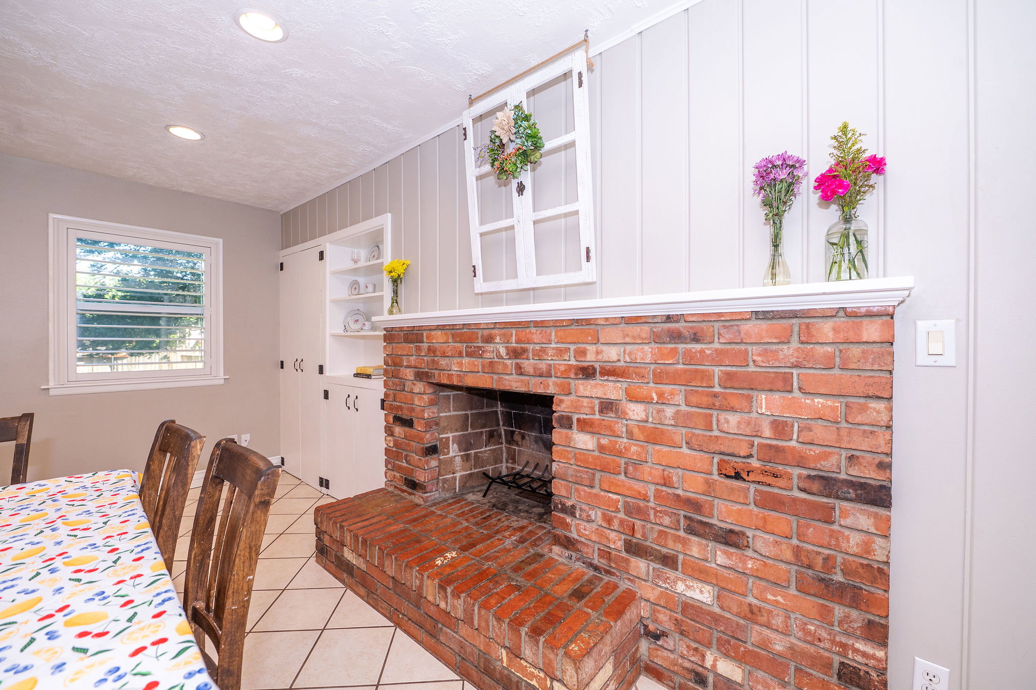 Brick fireplace with hearth, white mantel, and board and batten accent wall