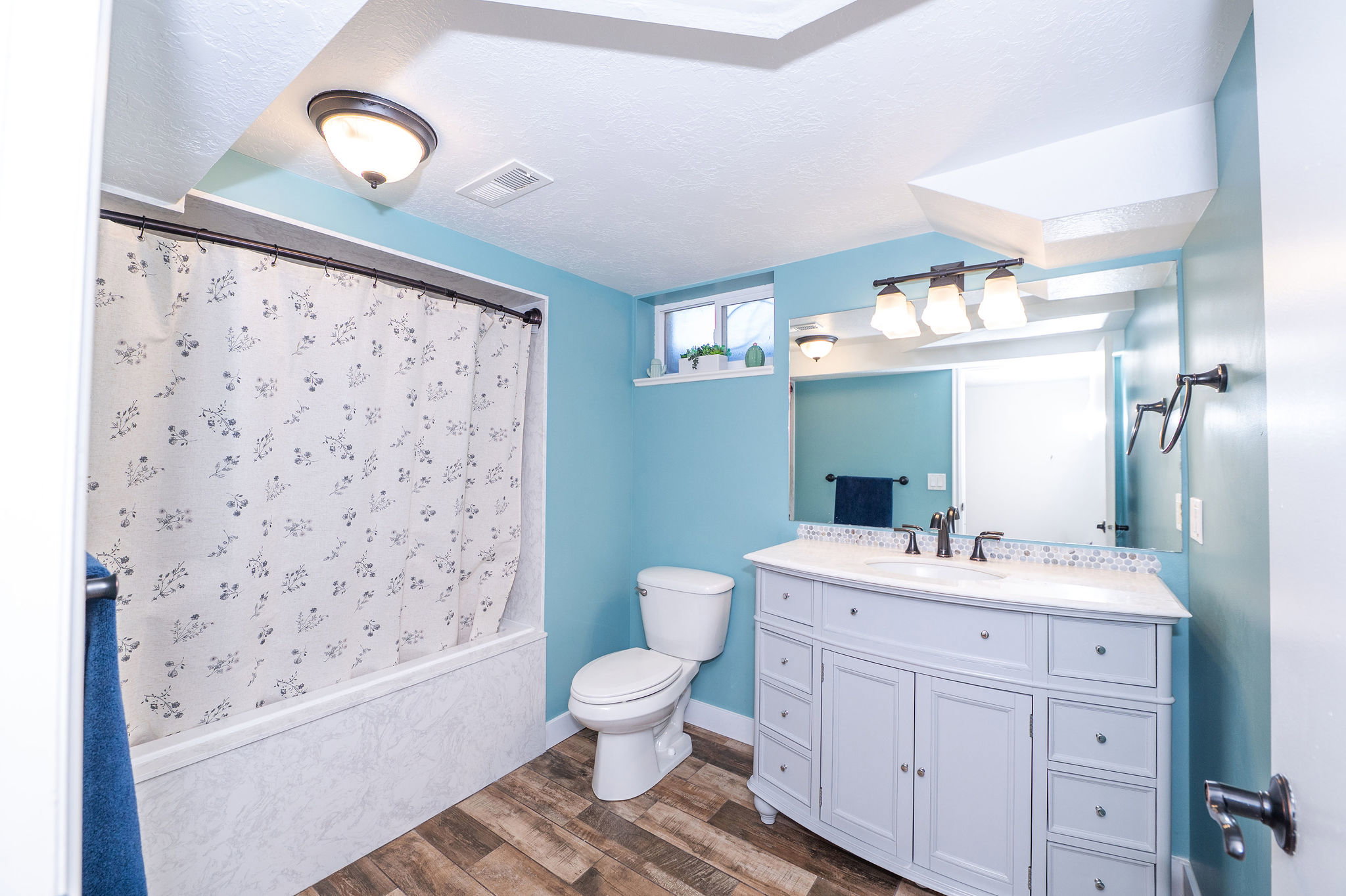 Full bathroom featuring a single vanity with storage cabinetry, a framed mirror, and a tub/shower combination