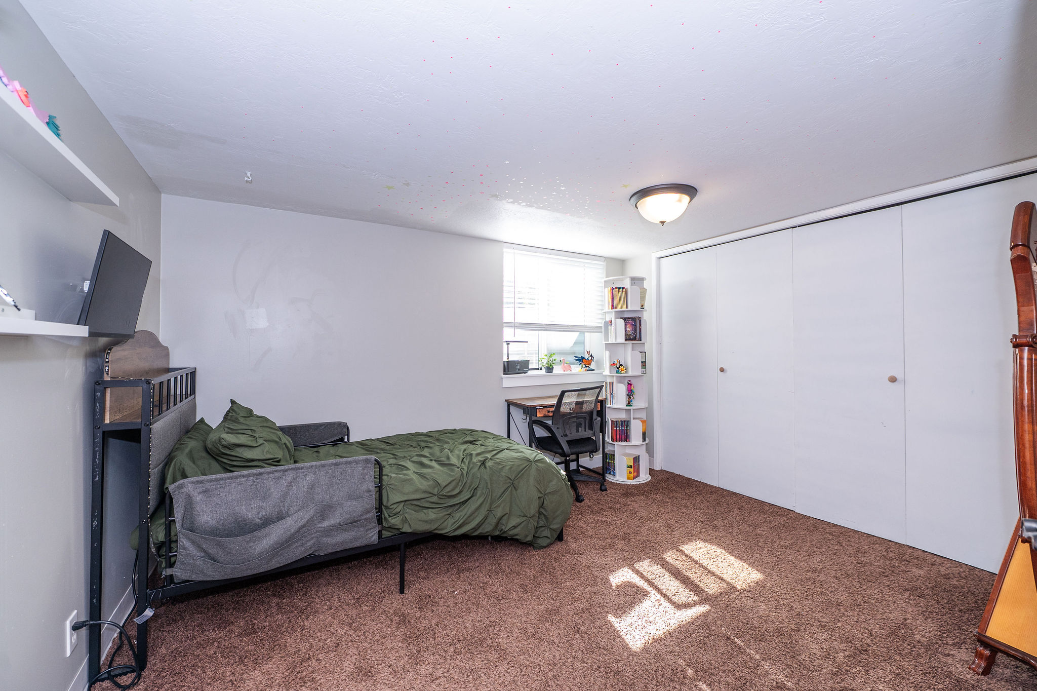 Bedroom featuring wall-to-wall carpeting, a window with blinds, and white walls