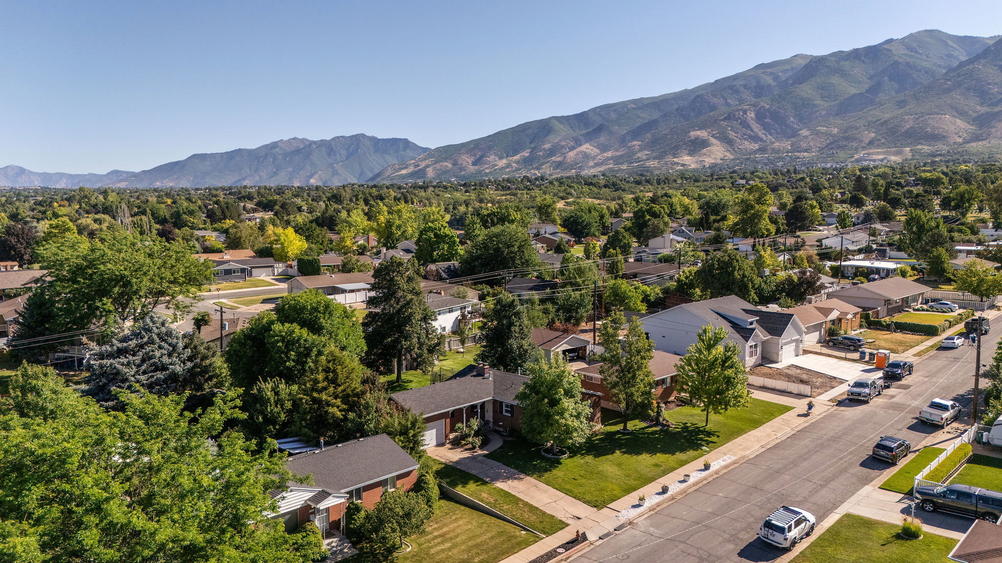 Residential properties featuring mature trees and mountain scenery