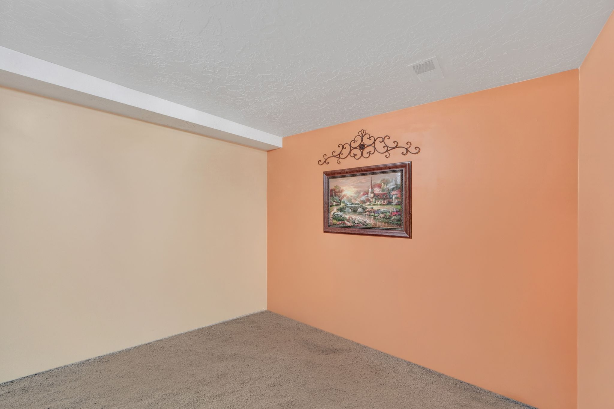 Carpeted room featuring a white textured ceiling and light-toned walls