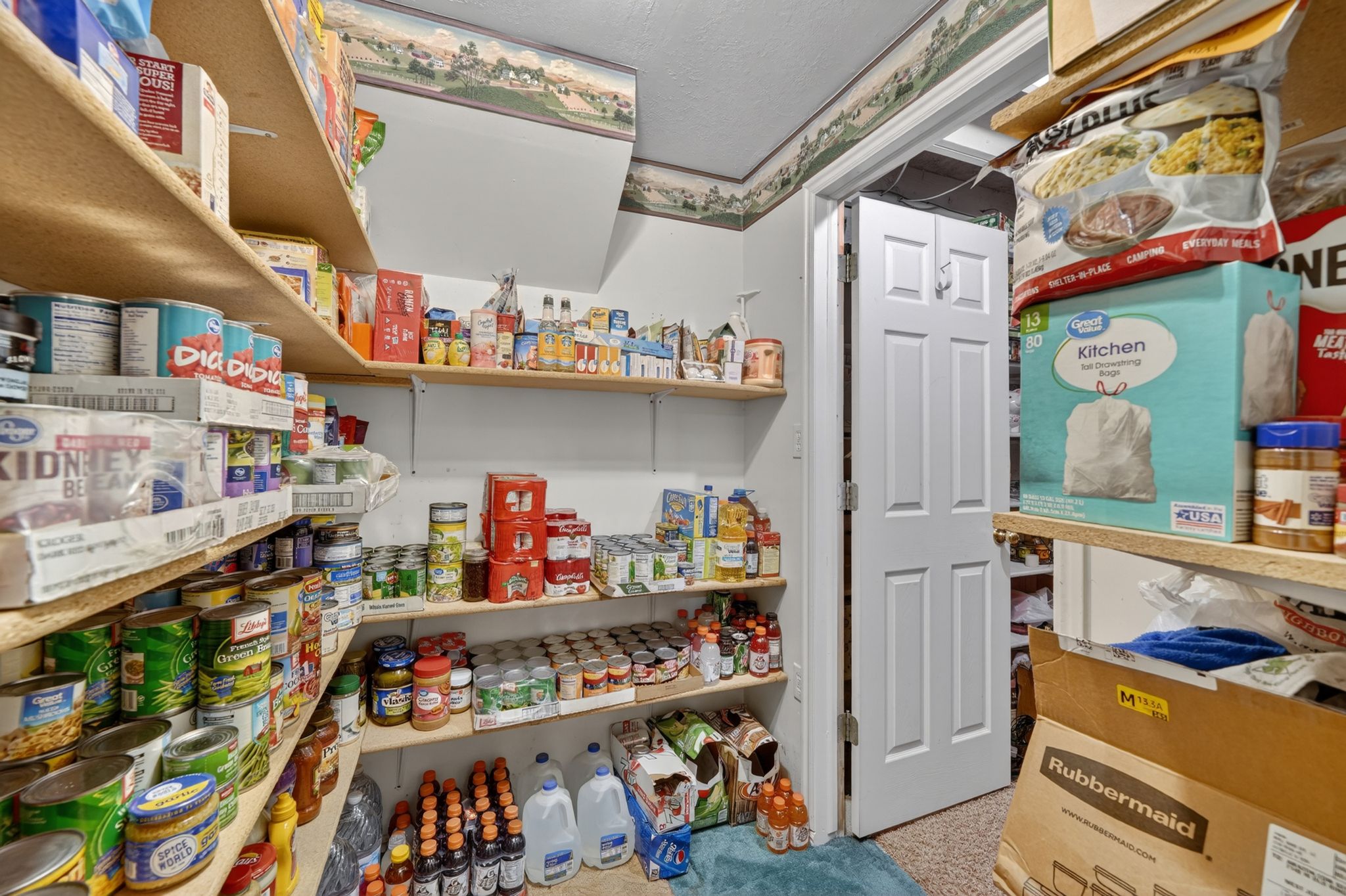 Spacious pantry featuring multiple levels of built-in wood shelving for ample storage