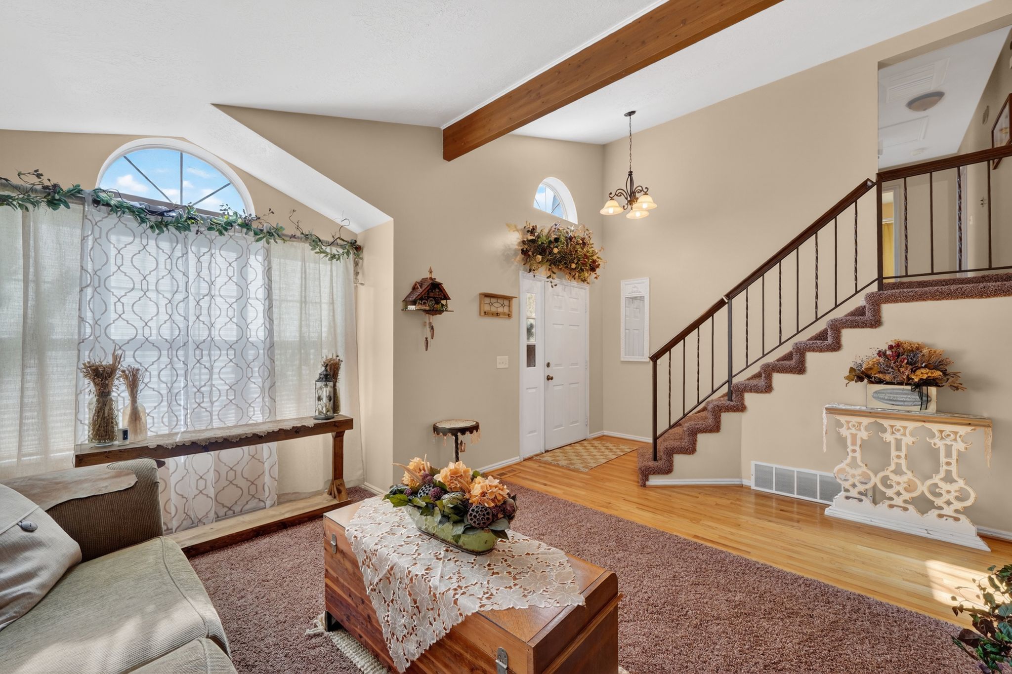 Two-story living area with vaulted ceilings and a prominent wood-finish beam