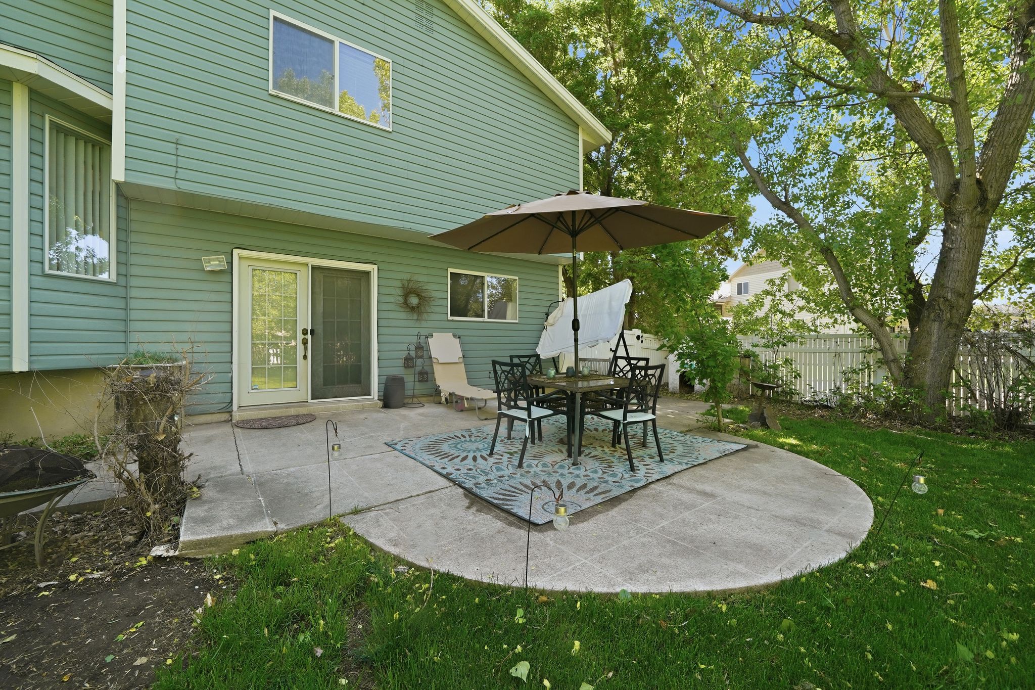 Circular concrete patio featuring a grass lawn surround and mature trees