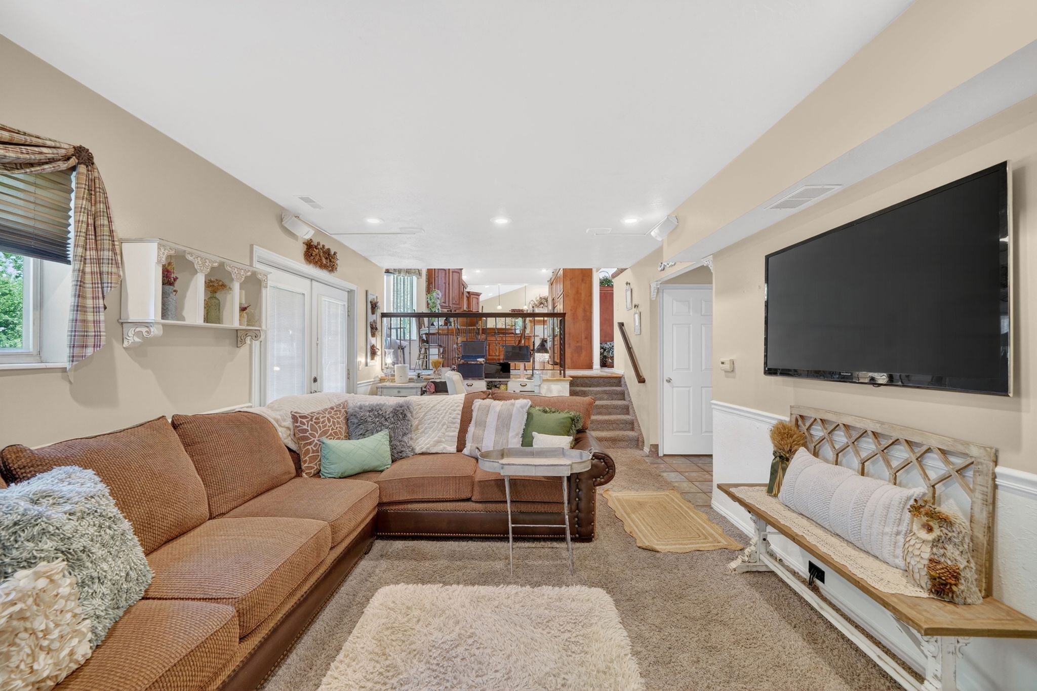 Finished lower level featuring recessed lighting, carpet flooring, a wall-mounted television, and wainscoting
