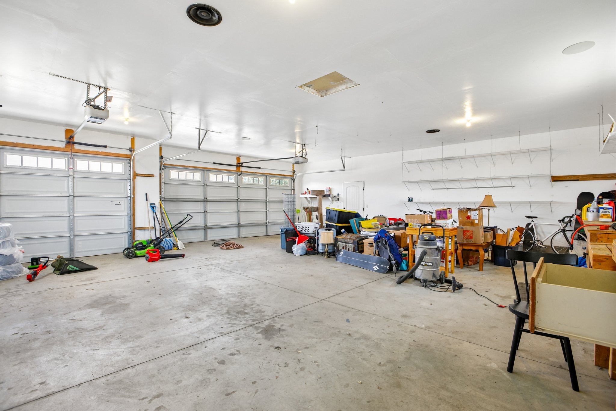 Spacious garage featuring two overhead doors with transom windows