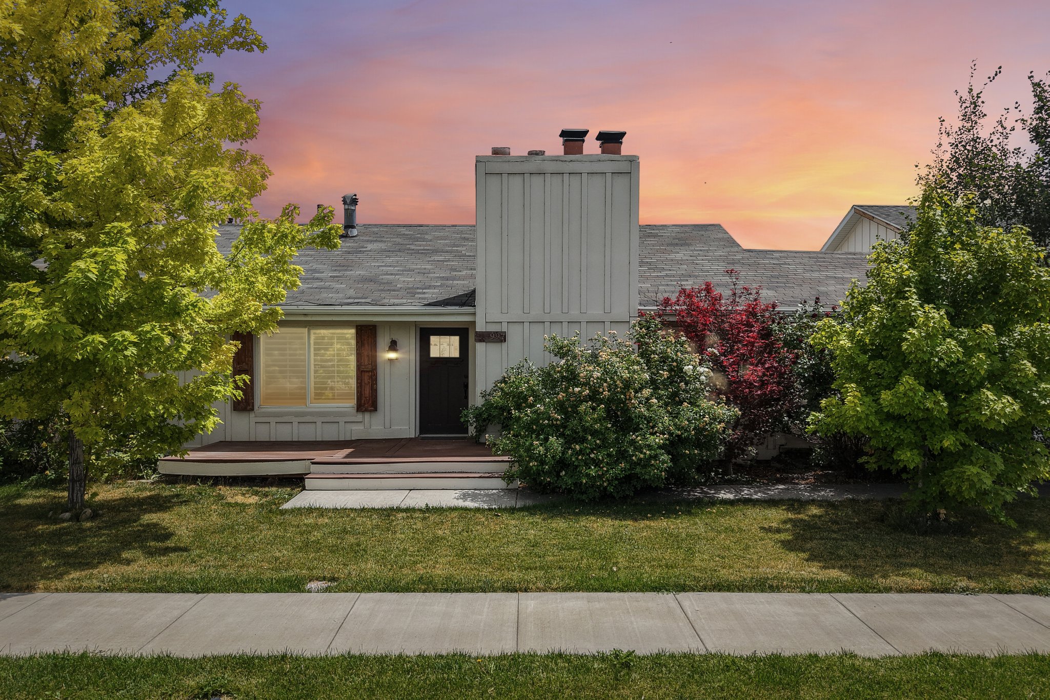 Single-story home featuring a gray shingle roof, light-colored siding, and a prominent chimney structure