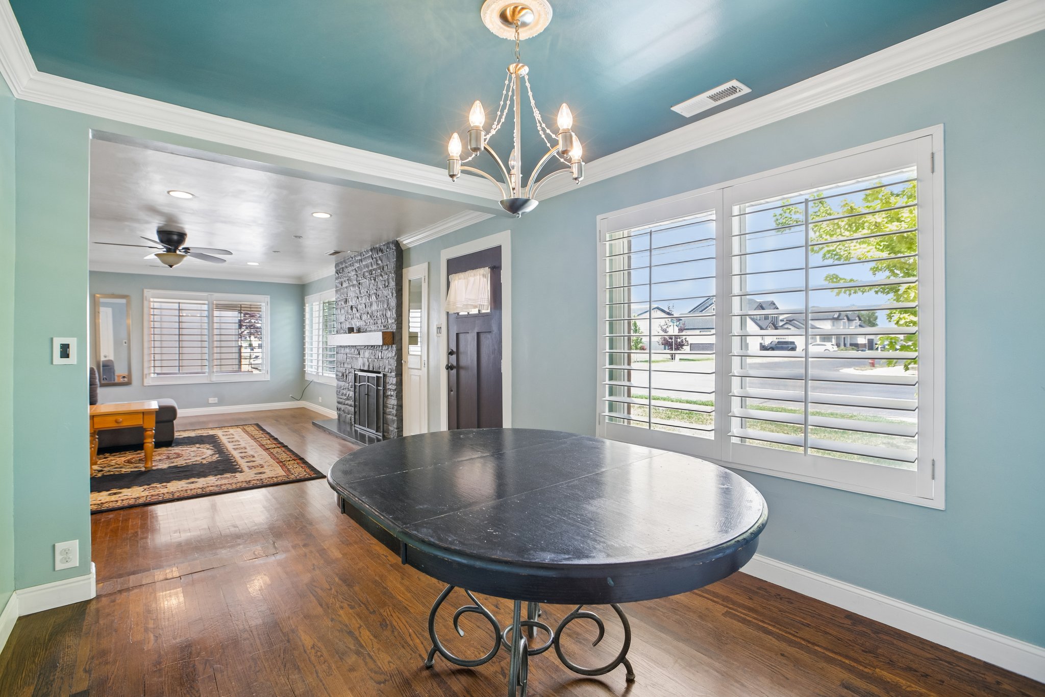 Dining area featuring a decorative chandelier, white crown molding, and hardwood flooring