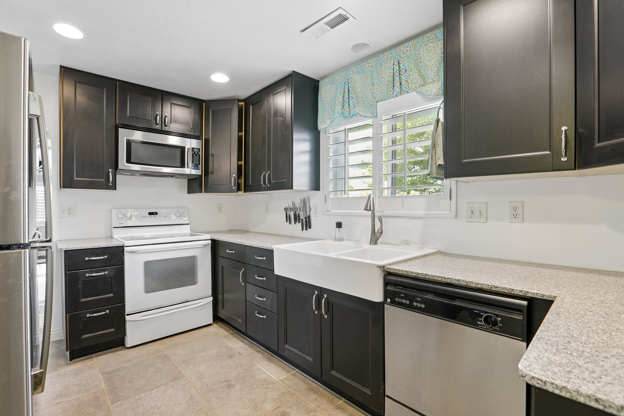 Kitchen with dark cabinetry and light-colored countertops
