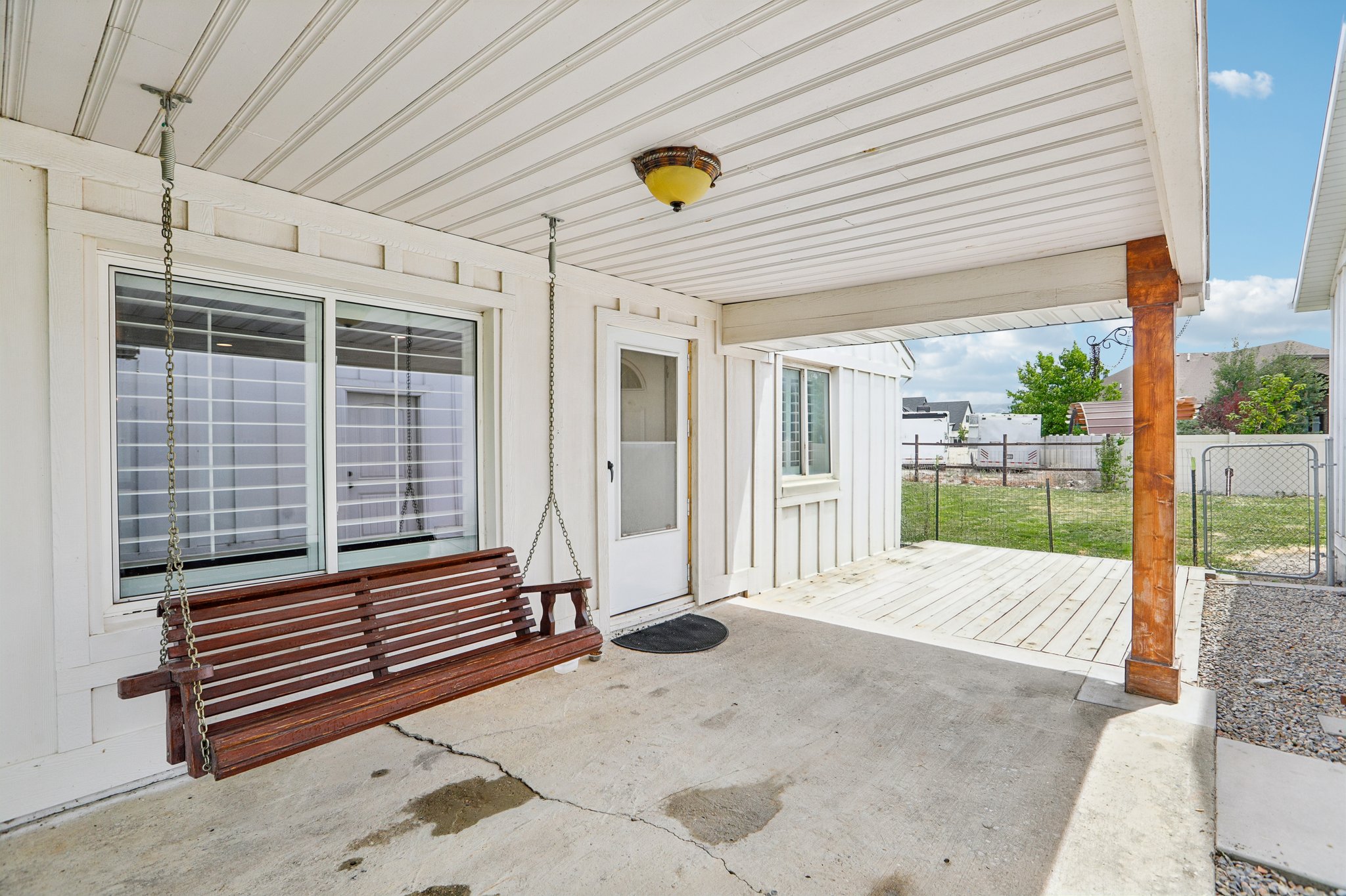 Covered patio area featuring a concrete slab, wood deck, and a single wood structural column