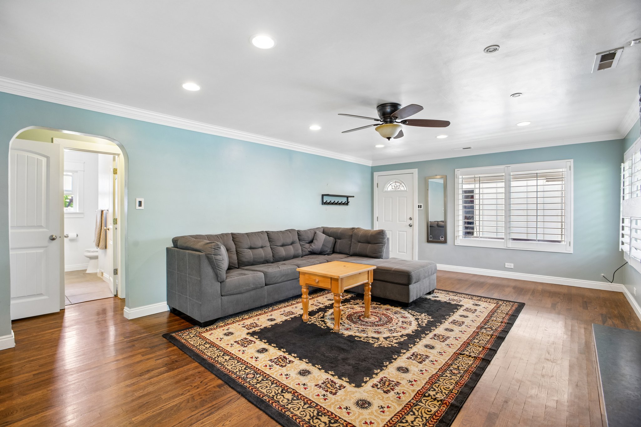 Spacious living area featuring wood-finish flooring, recessed lighting, and a ceiling fan