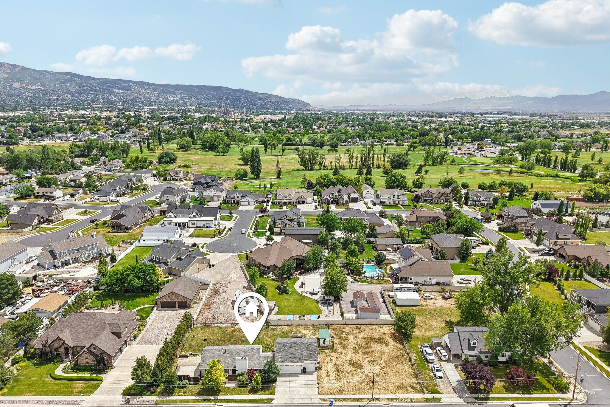Aerial view of a residential neighborhood featuring established homes with varied architectural styles, mature landscaping, and paved streets