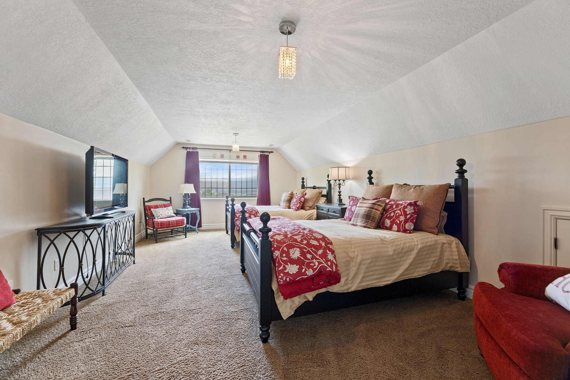 Spacious room featuring sloped ceilings, two large windows, and wall-to-wall carpeting, large walk-in closet