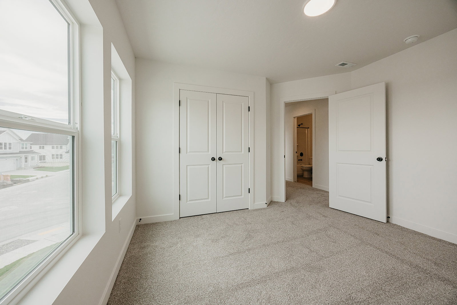 Room featuring light gray carpeting, crisp white walls, and a recessed ceiling light