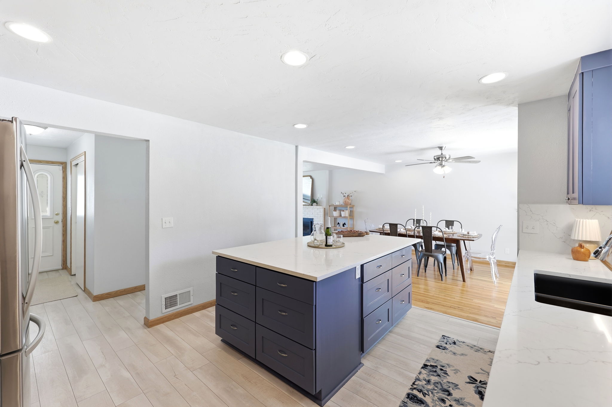 Kitchen island with white countertop, integrated sink, and abundant drawer storage