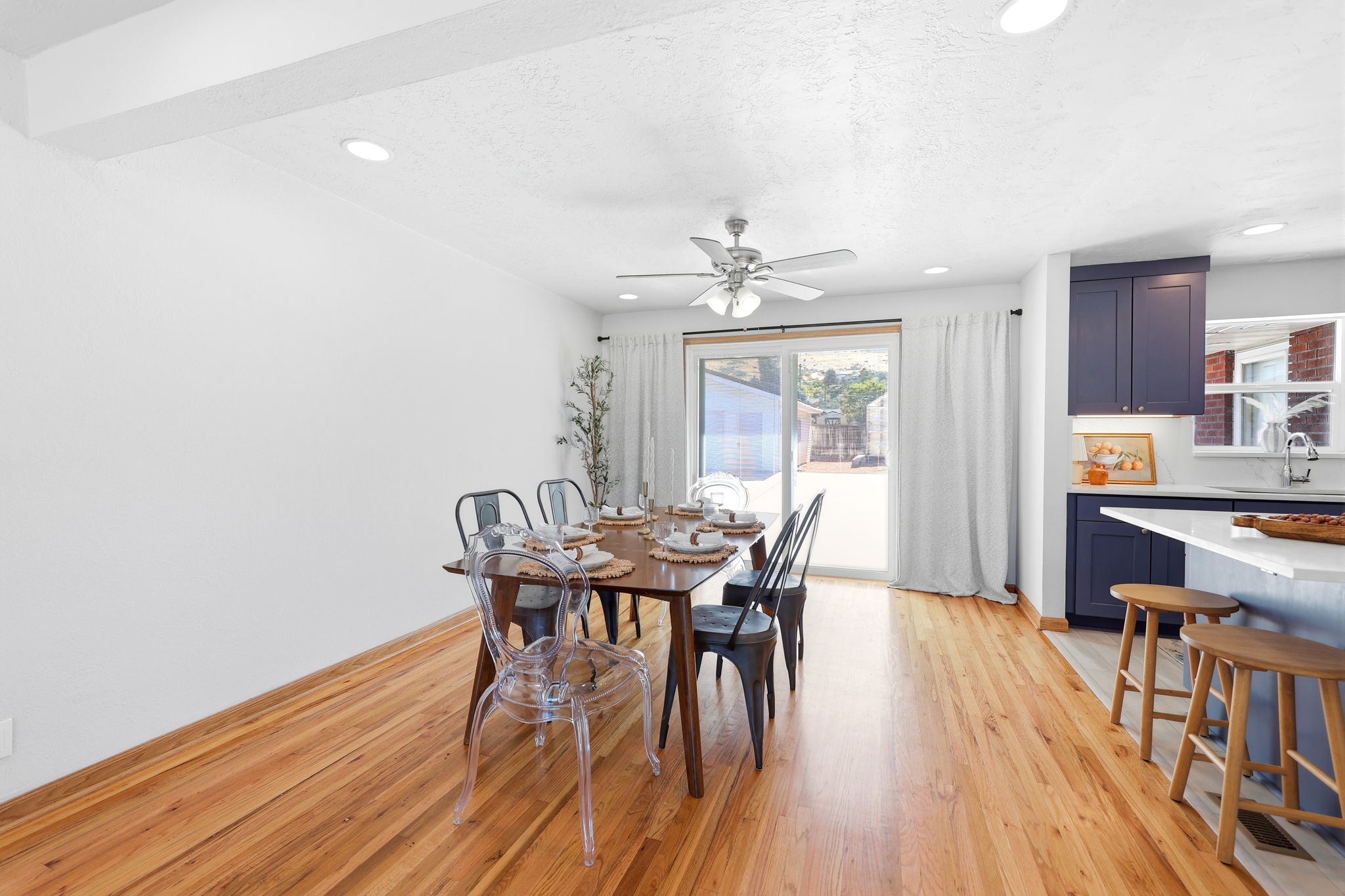 Open-concept living space featuring wood-finish flooring, recessed lighting, and a ceiling fan