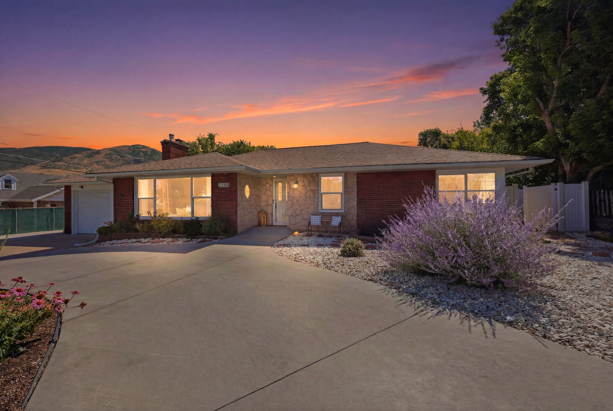 Ranch-style residence featuring a brick facade, stone accents, and a front-facing garage