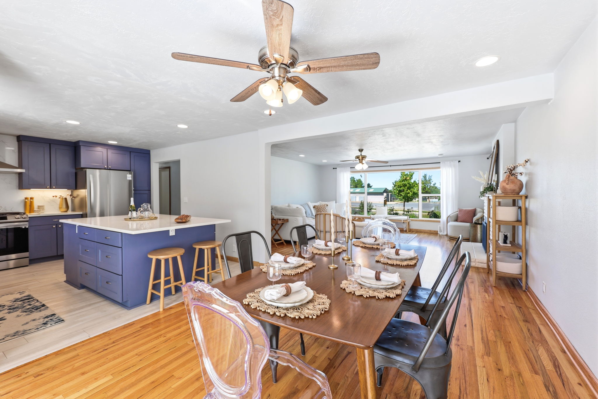 Dining area featuring wood-finish flooring, a contemporary ceiling fan, and an open concept layout