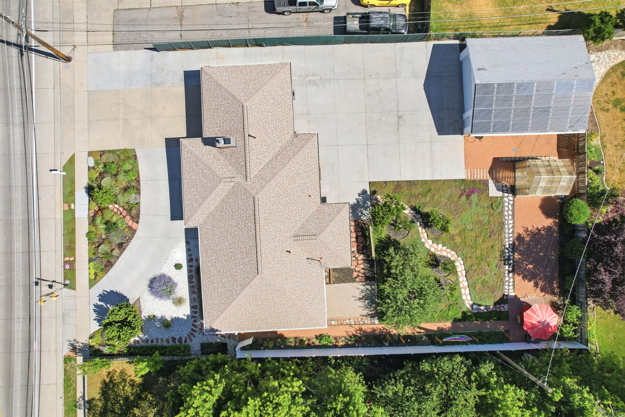 Expansive property featuring a multi-gabled roofline, concrete driveway, and a detached structure