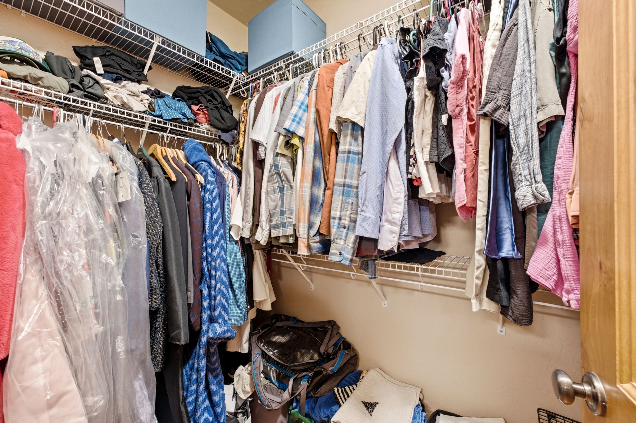 Spacious walk-in closet featuring built-in wire shelving and hanging rods