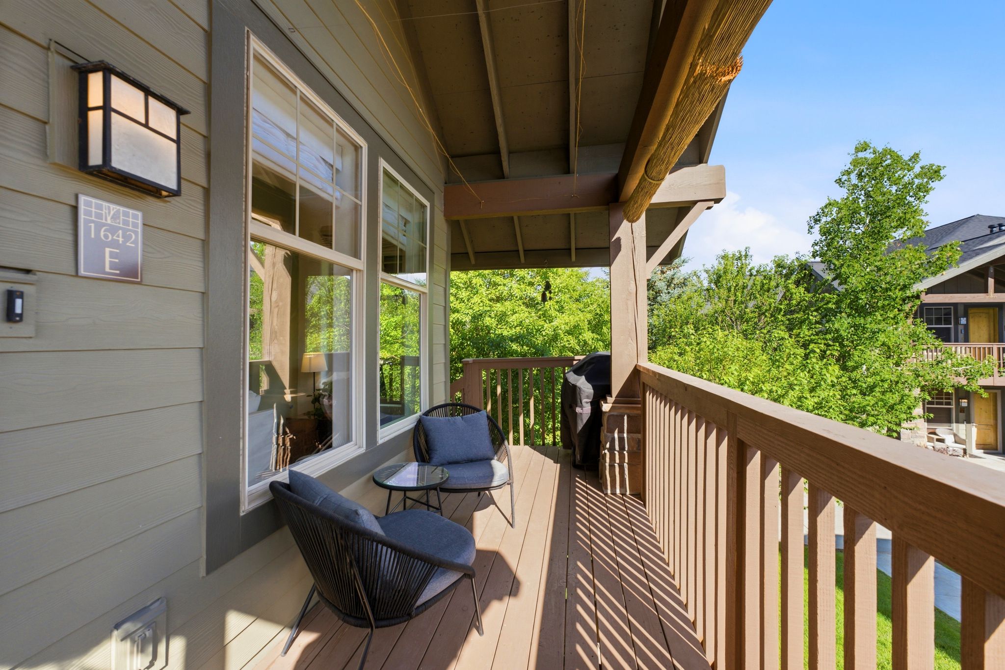 Covered private balcony featuring wood-finish decking and railing