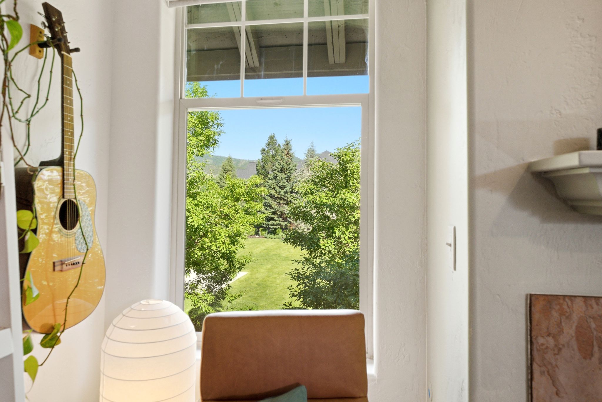 Window overlooking a landscape of verdant trees and hills