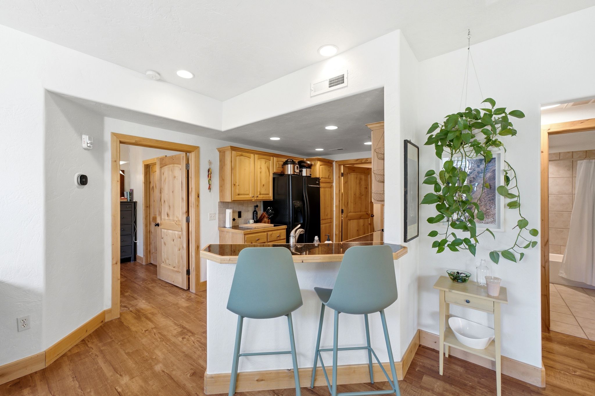 Kitchen bar seating featuring a wood-finish countertop, light wood cabinetry, and recessed lighting