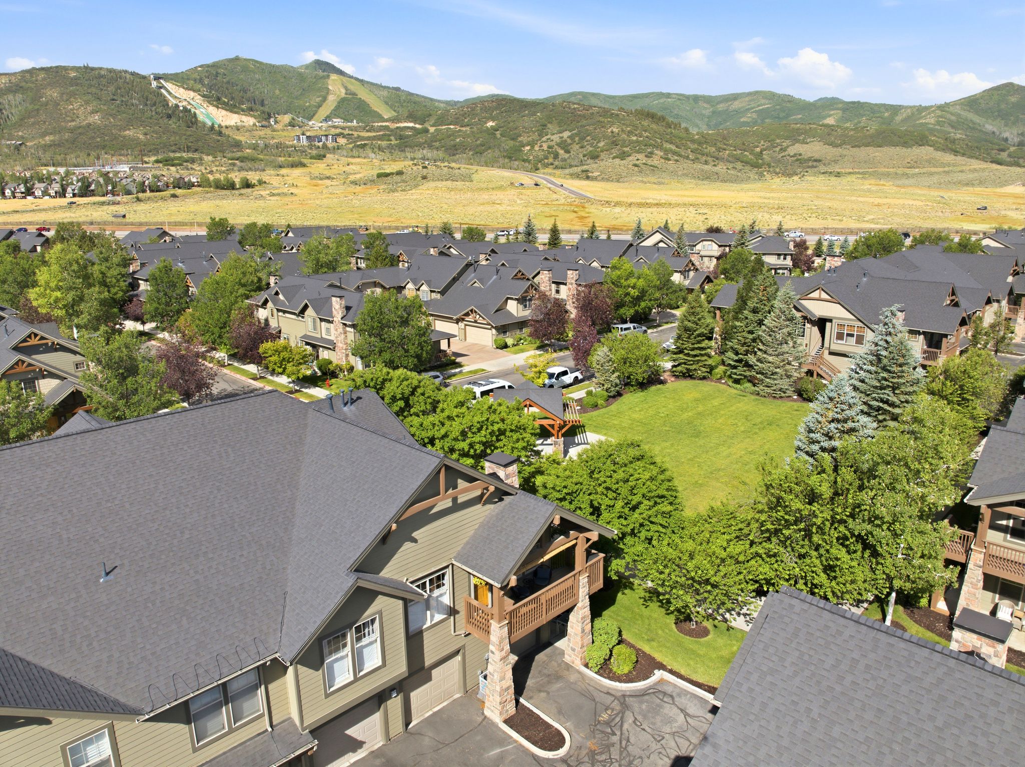 Residential community featuring multi-level dwellings with stone accents and dark shingle roofing