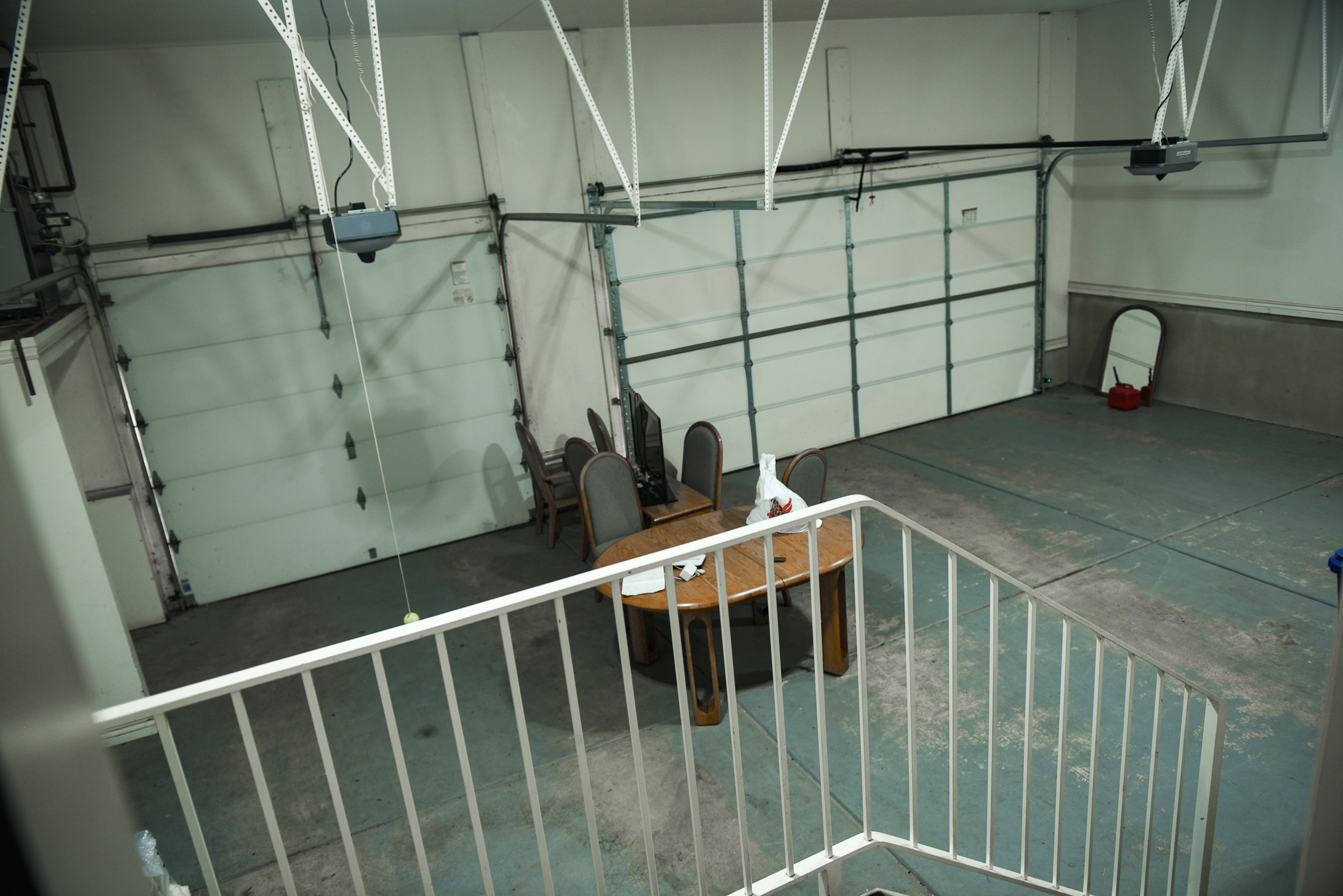 Spacious garage featuring two overhead doors with automated openers and track systems