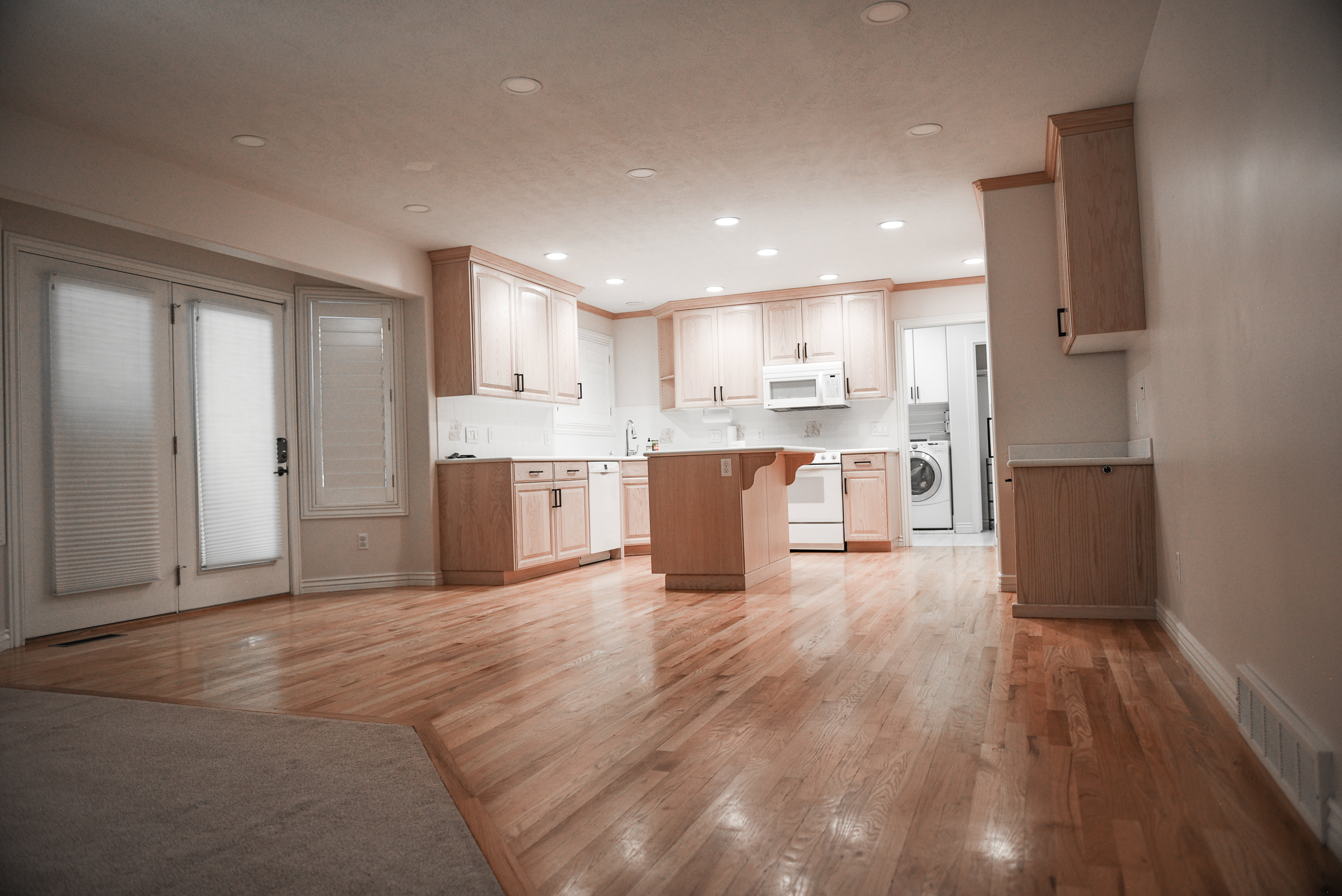 Kitchen with light wood-finish cabinetry and white appliances