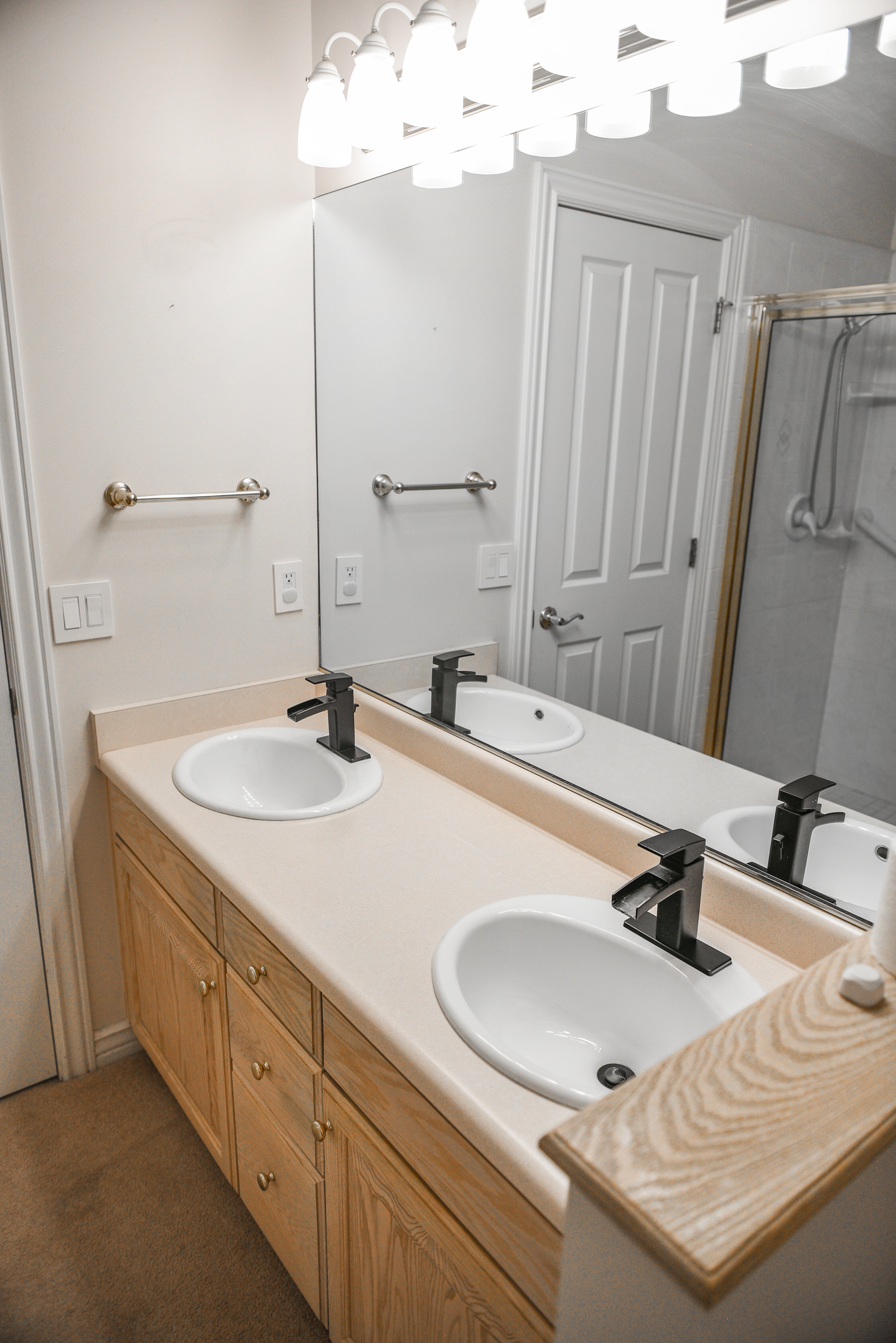 Double vanity featuring integrated sinks, light-toned countertop, and matte black faucets