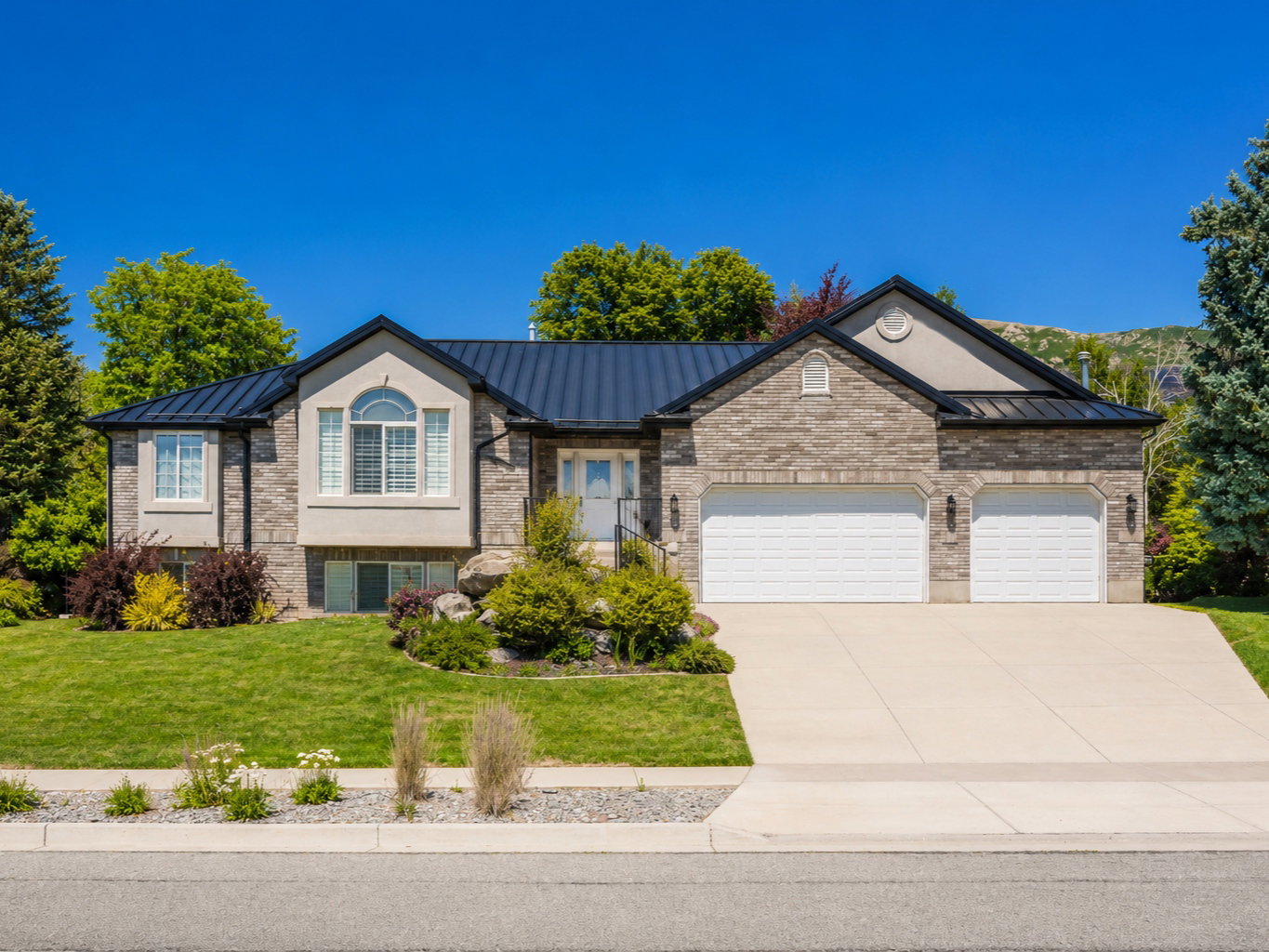 Stone and stucco exterior with a dark metal roof
