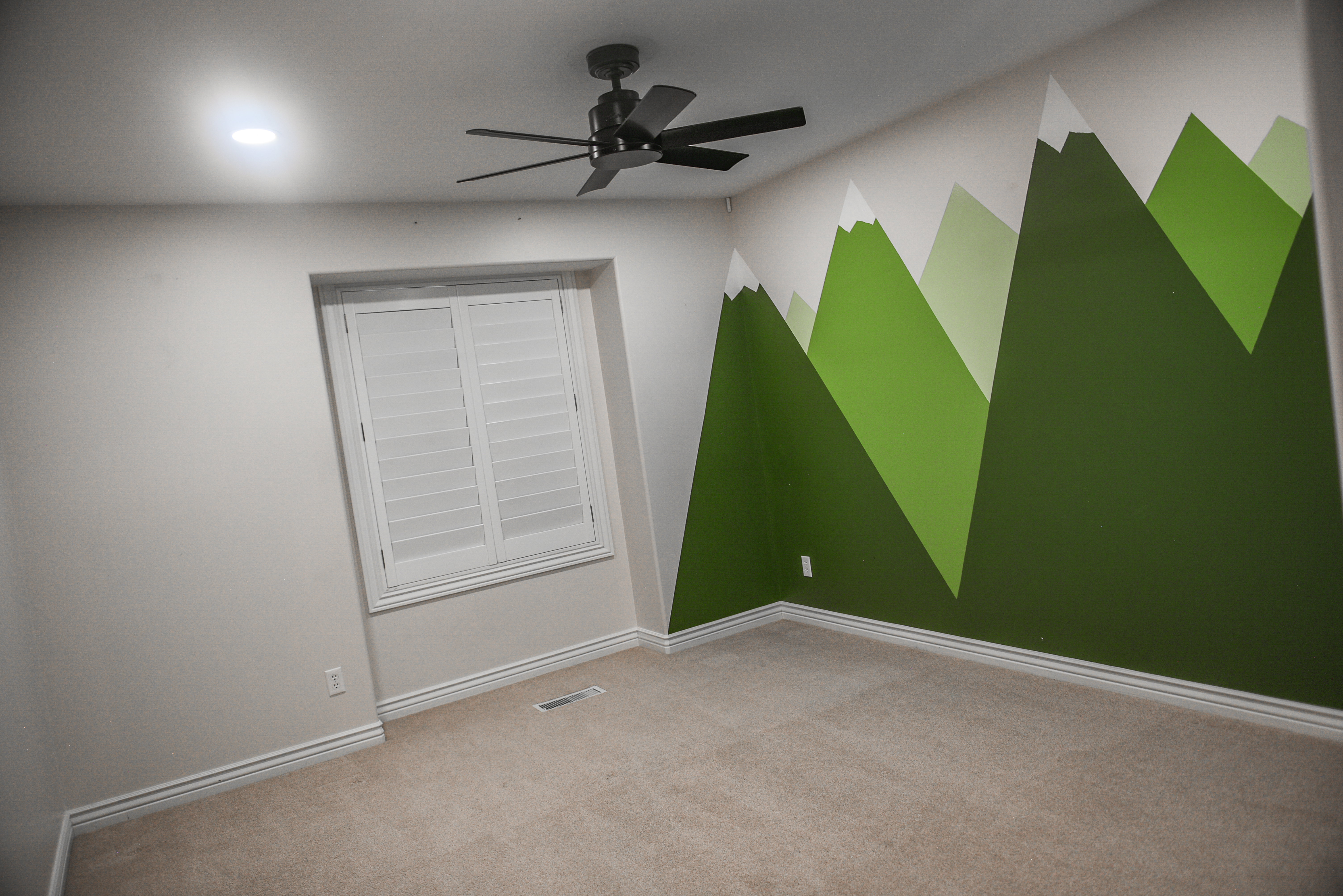 Carpeted room featuring a geometric mountain mural, recessed lighting, and a ceiling fan