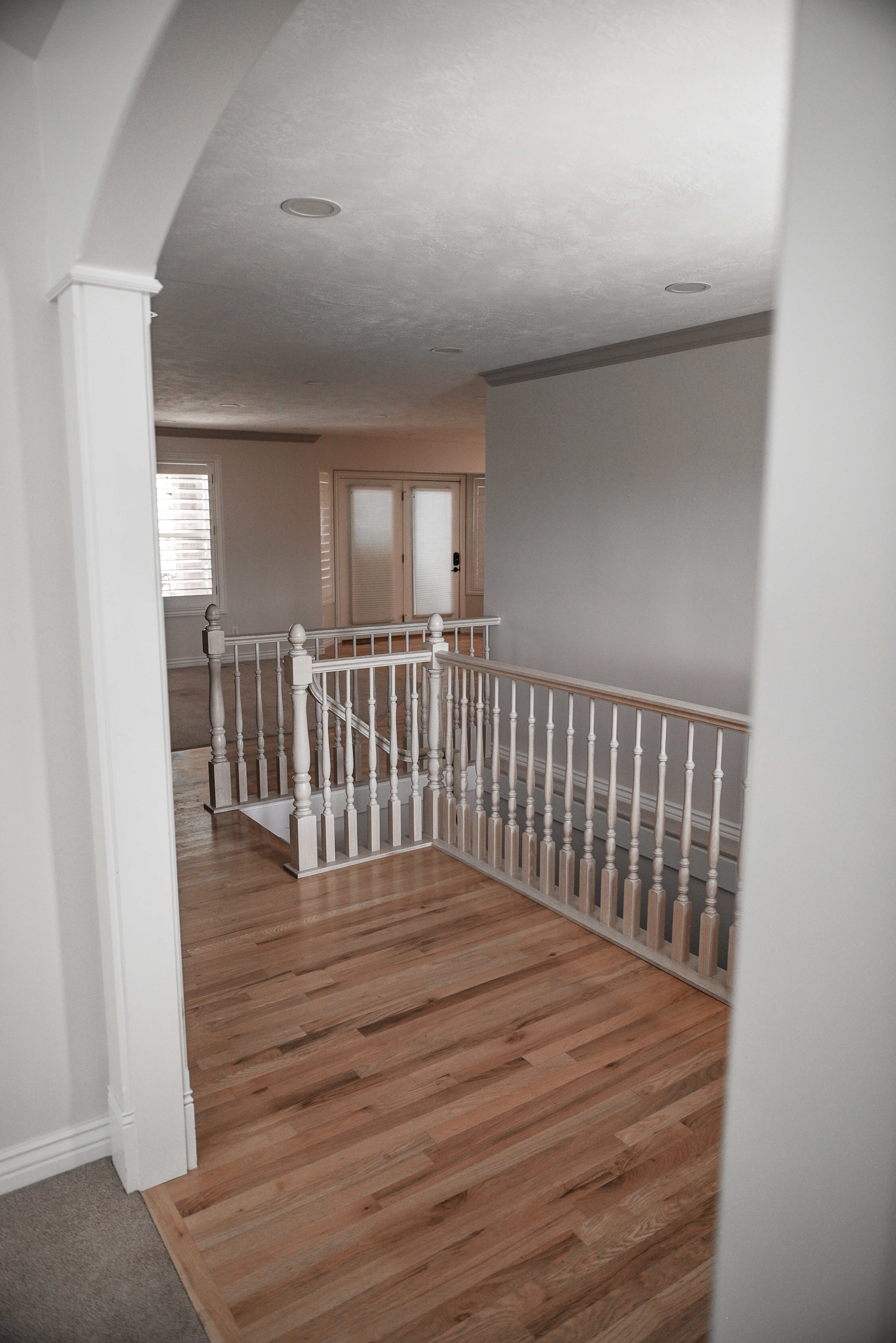 Hardwood flooring extending through an arched entryway