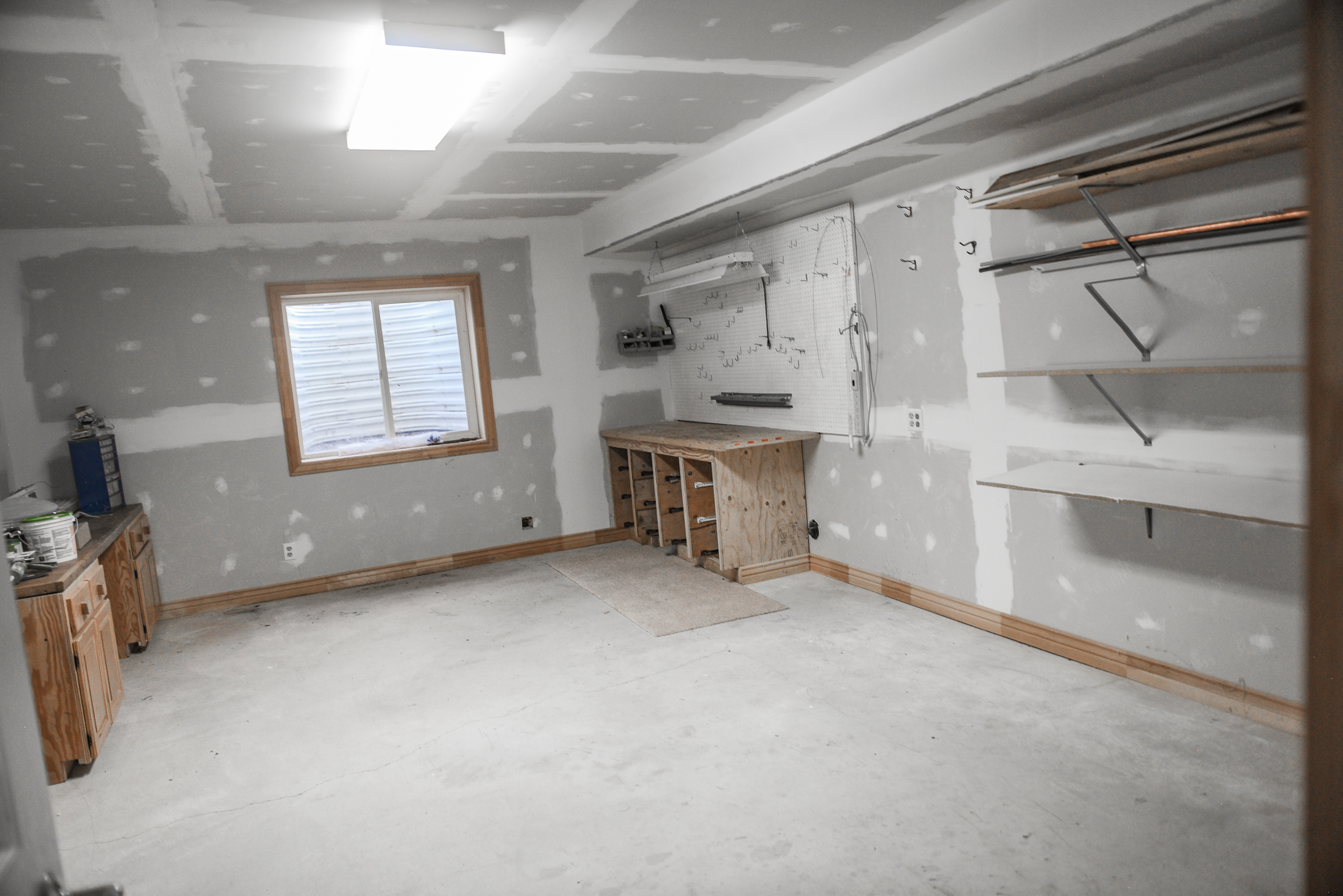 Unfinished room with drywall installation, exposed ceiling joists, and a concrete floor