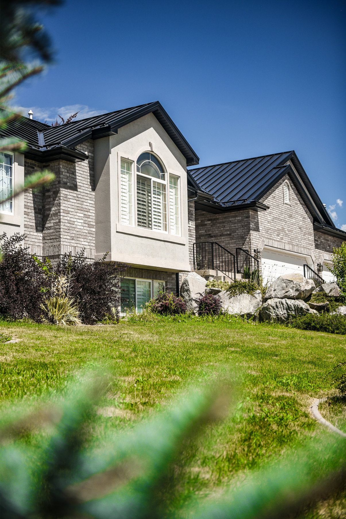 Stone veneer siding exterior with a dark metal roof