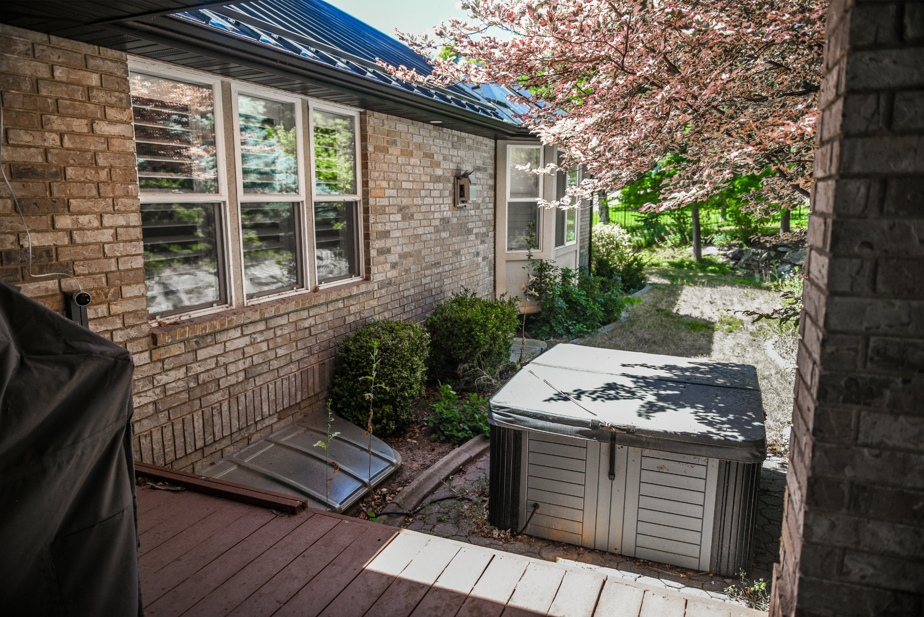 Exterior brick siding with white window frames and a dark metal roof