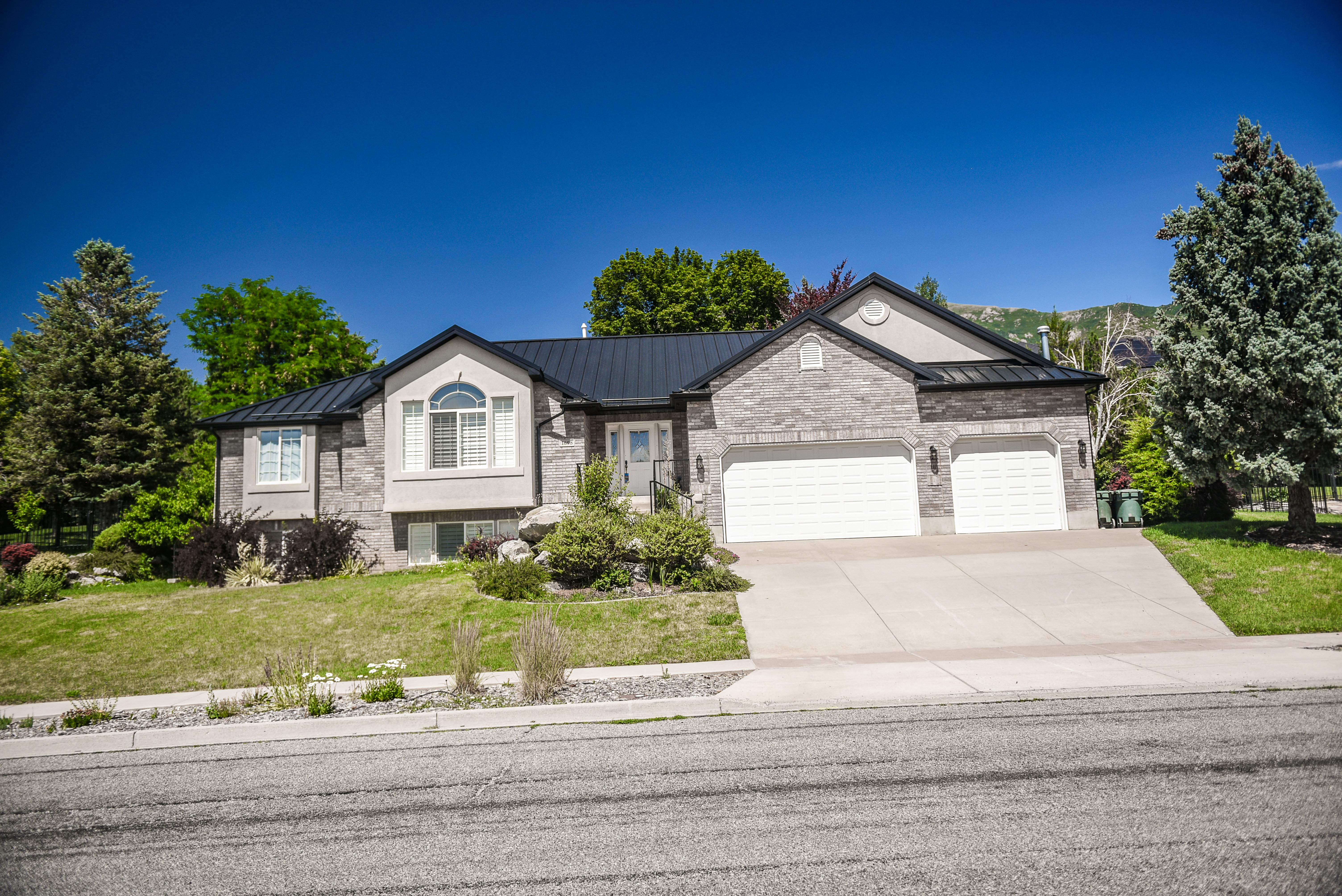 Stone-clad exterior featuring a prominent arched window and a dark metal roof