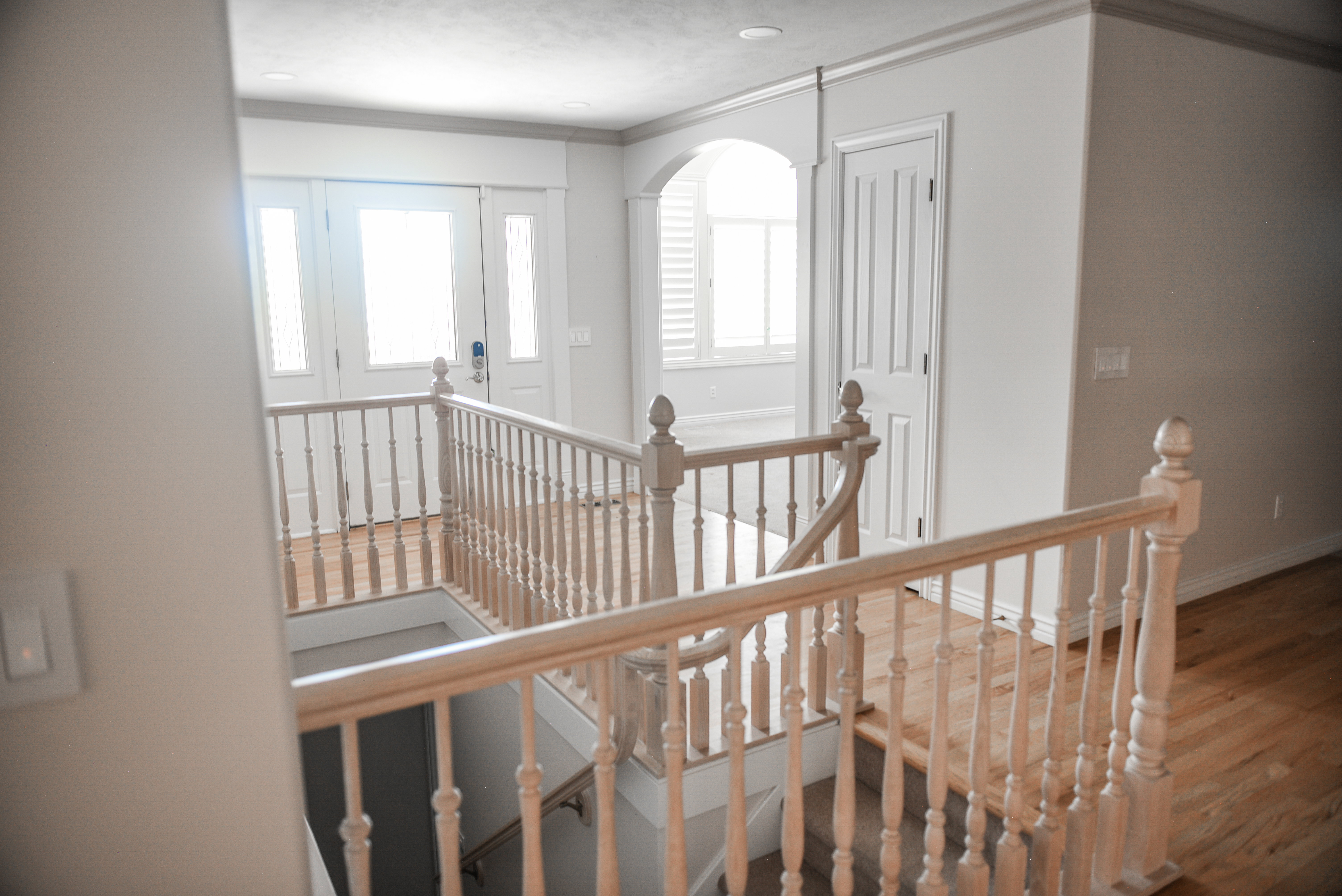 Upper-level landing with wood-finish flooring and a light wood balustrade