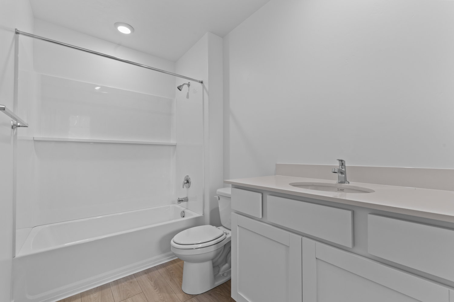 Bathroom featuring a white vanity with slab countertop, undermount sink, and chrome faucet
