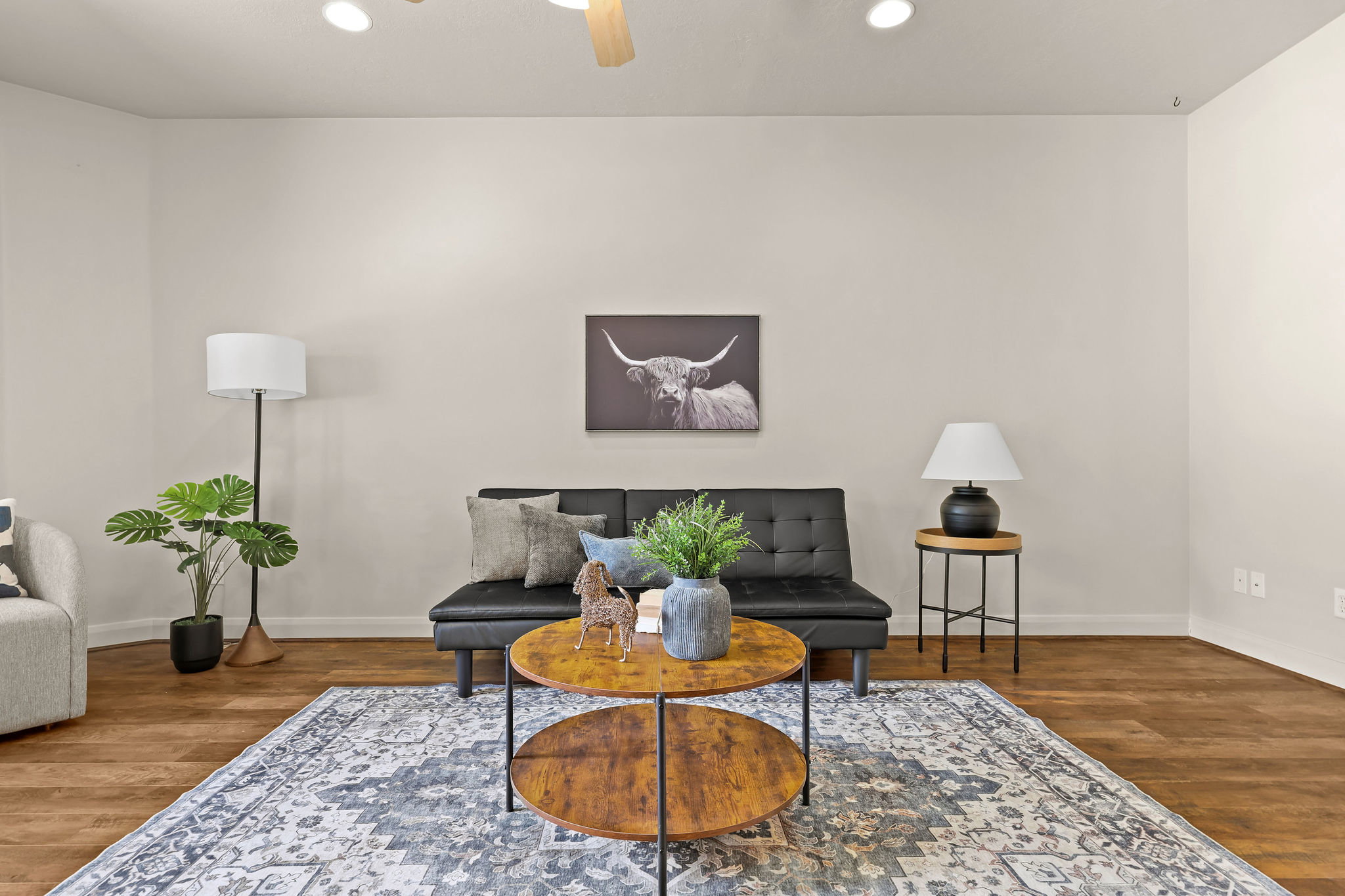 Spacious room featuring laminate wood flooring, recessed ceiling lighting, and a ceiling fan